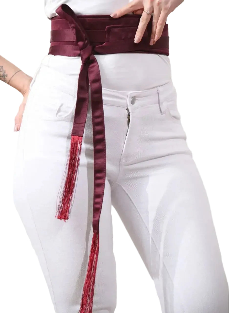 Palestinian Elegance embroidered satin belt in deep burgundy wrapped around waist with tassel ends