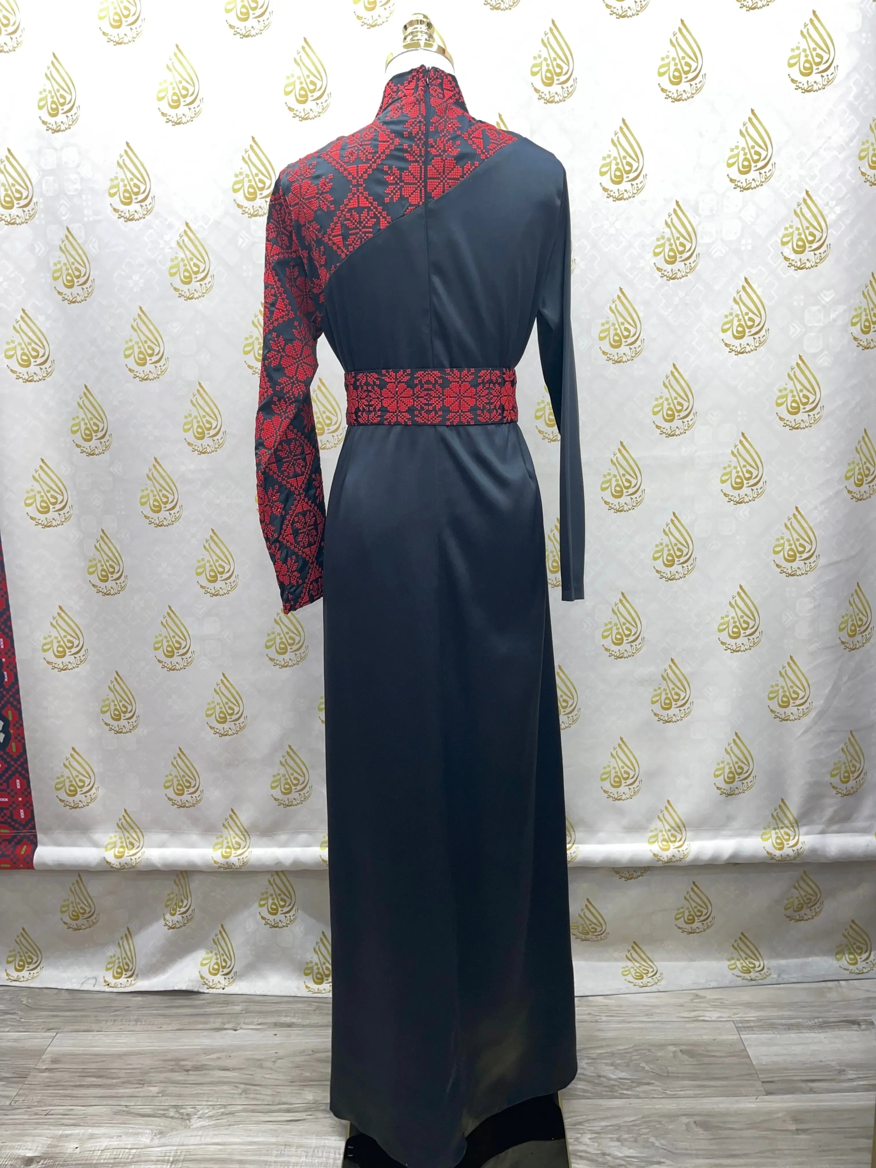 Back view of Palestinian Elegance embroidered satin dress in black with red embroidery and long sleeves