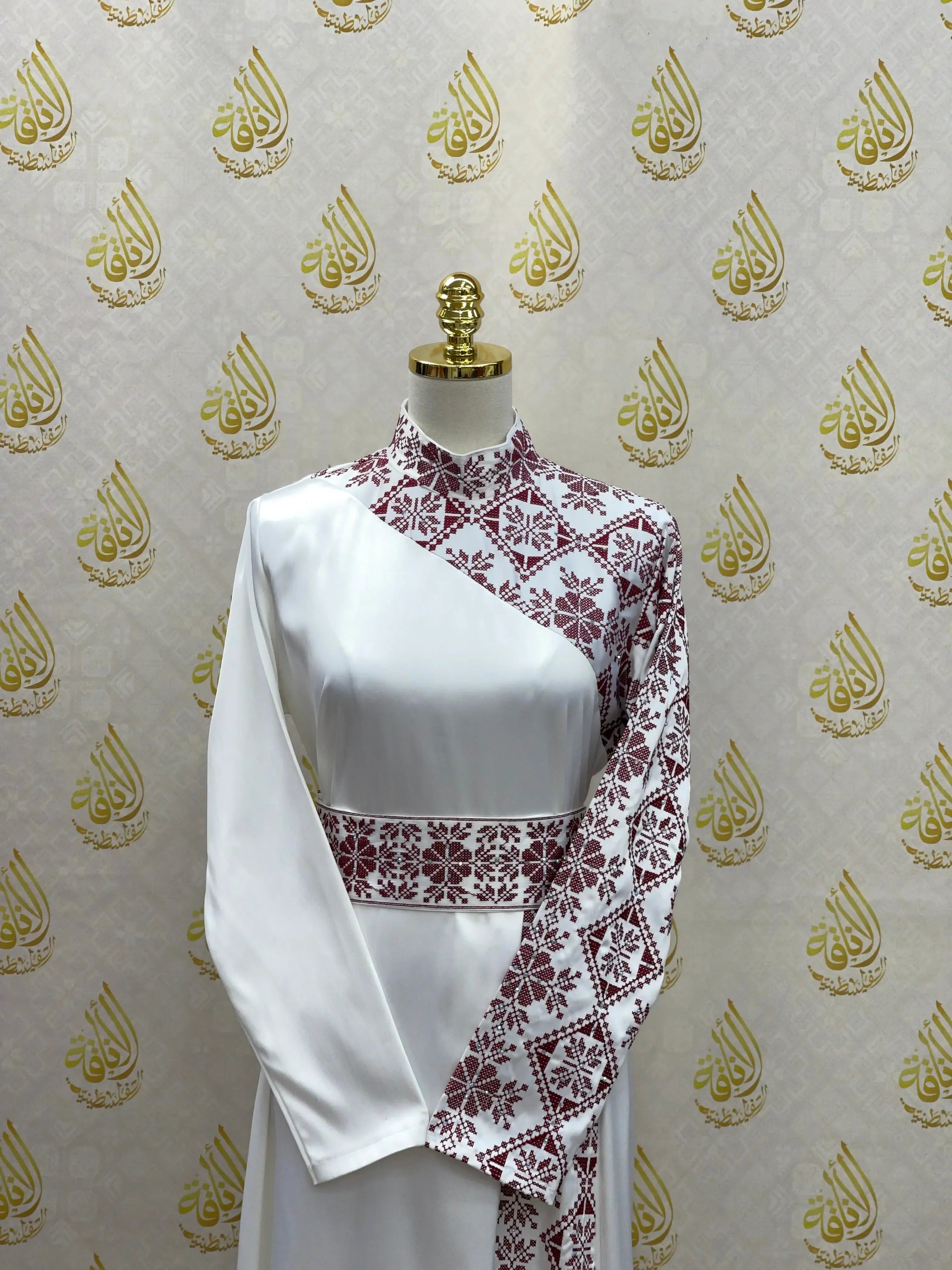 Palestinian Elegance embroidered satin dress with white satin and intricate maroon embroidery on one sleeve and bodice