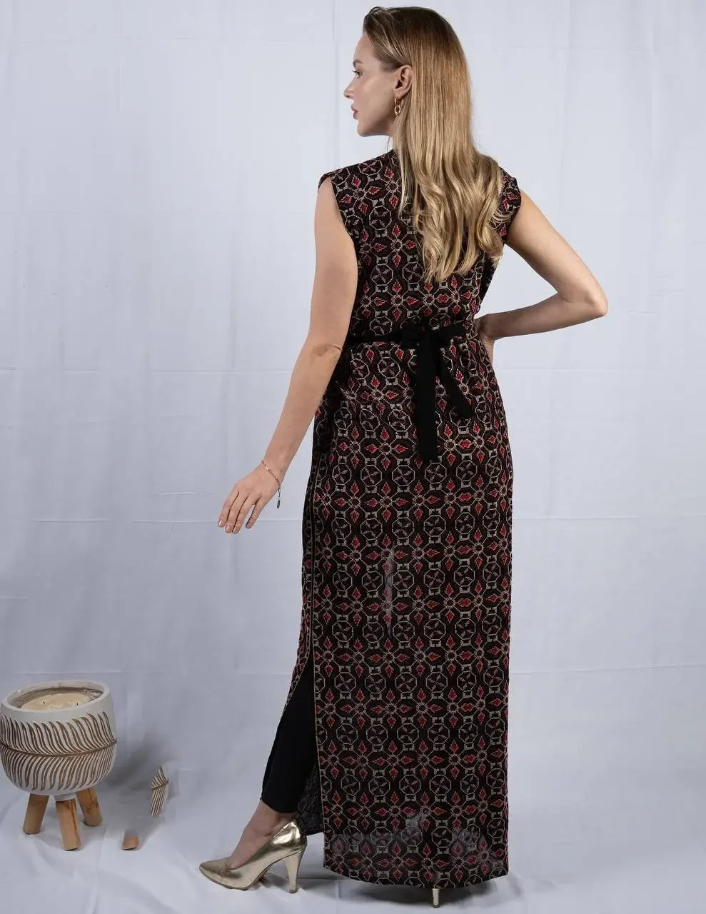 Palestinian Elegance embroidered sleeveless cardigan with intricate patterns worn by woman in gold heels