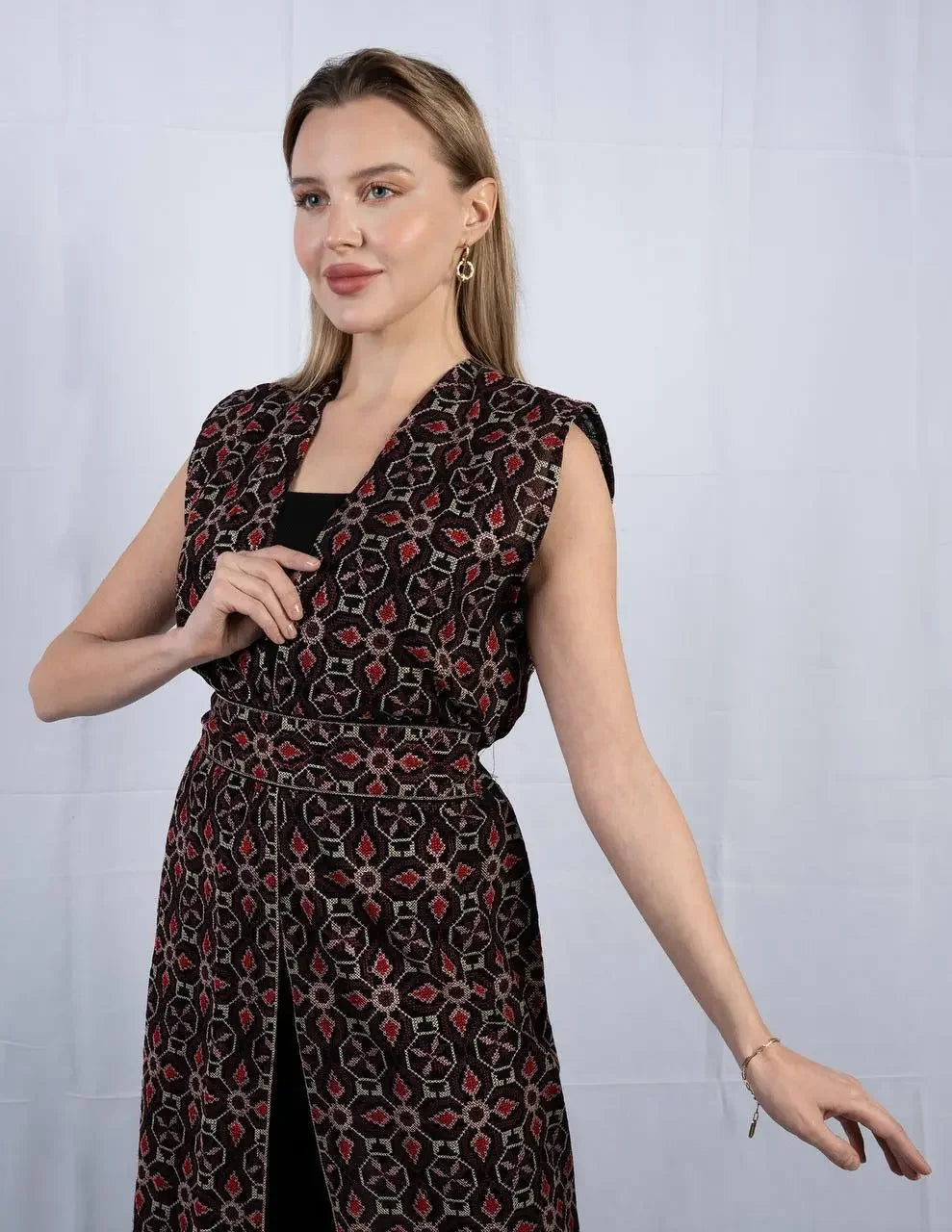 Palestinian Elegance embroidered sleeveless cardigan with intricate red and black patterns worn by a model