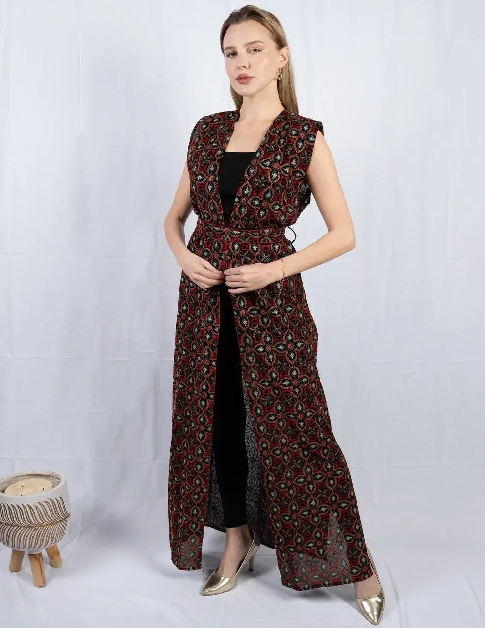 Palestinian Elegance embroidered sleeveless cardigan in black and red worn over black outfit with geometric patterns