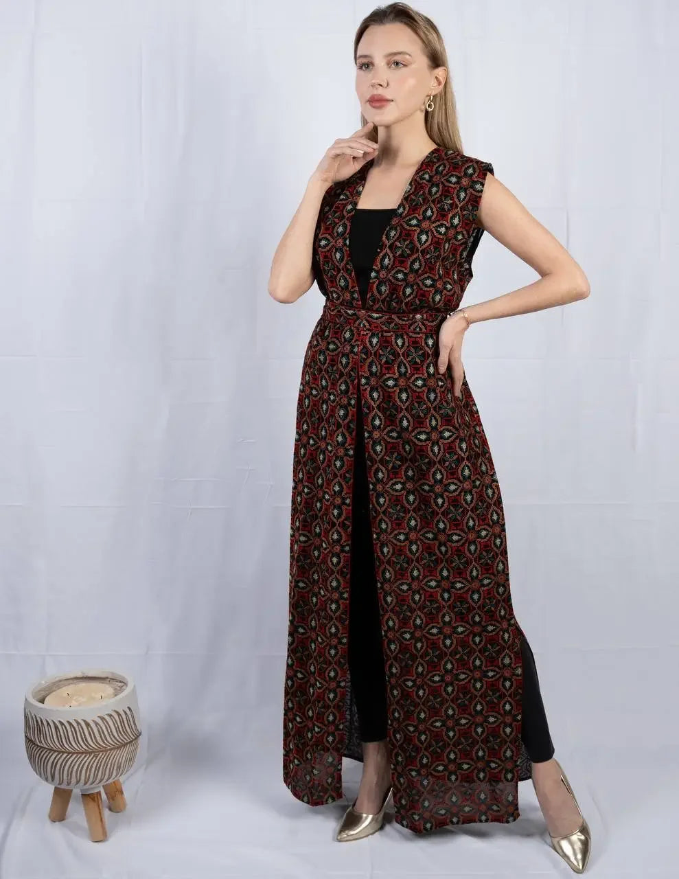 Palestinian Elegance embroidered sleeveless cardigan in black and red geometric pattern worn over black outfit