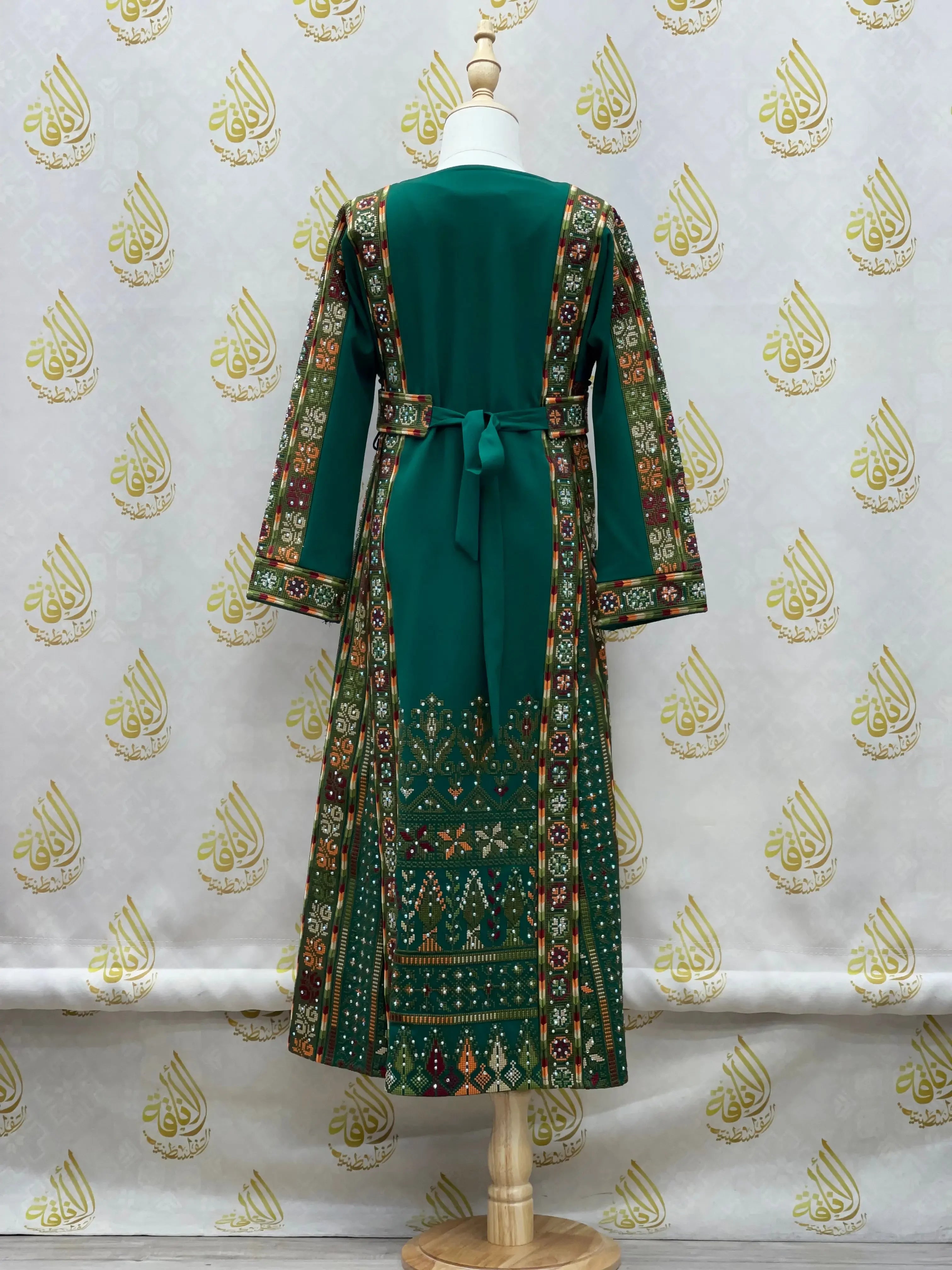 Green embroidered thoub for girls with intricate traditional Palestinian designs and long sleeves