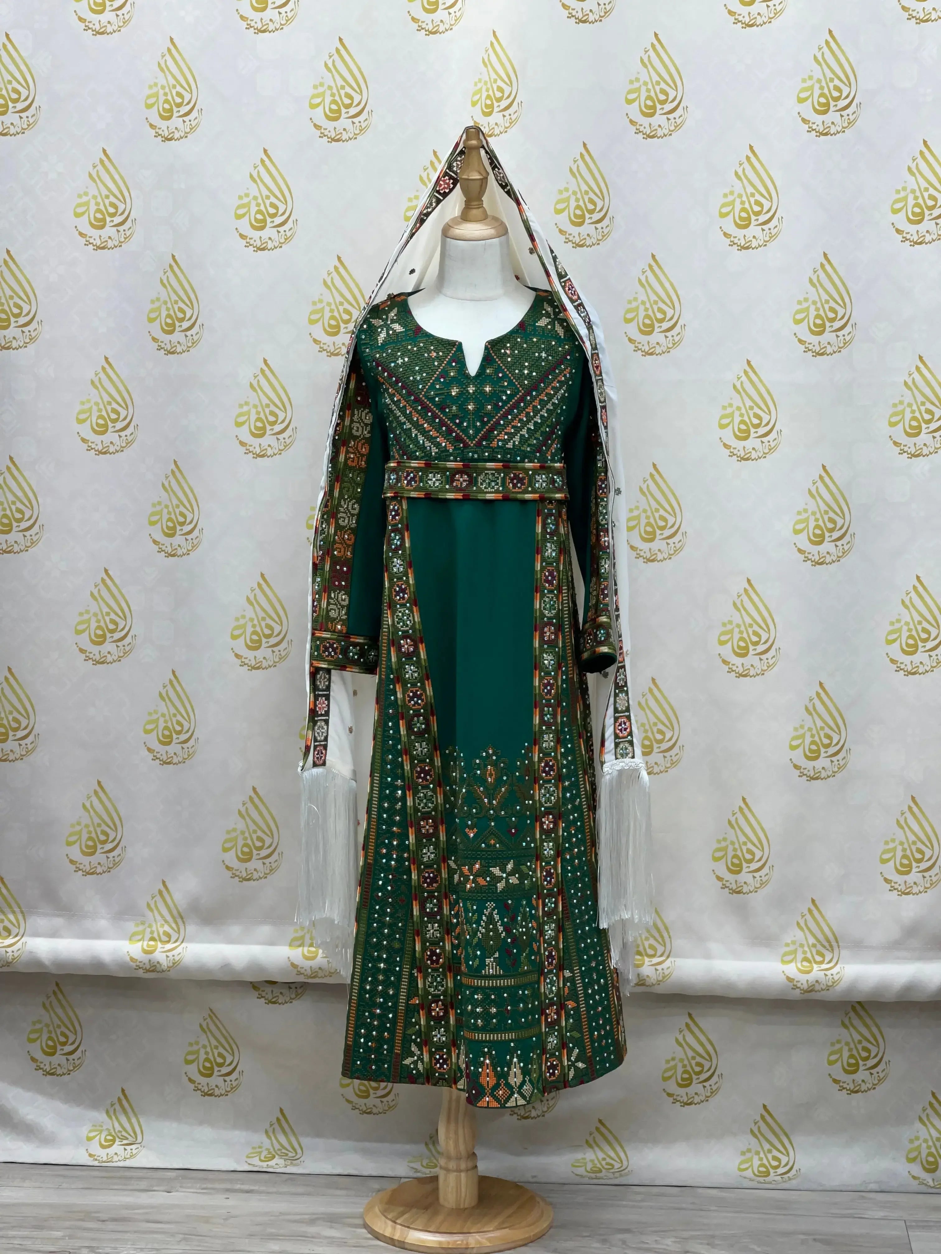 Green embroidered thoub for girls with intricate traditional Palestinian patterns on a mannequin