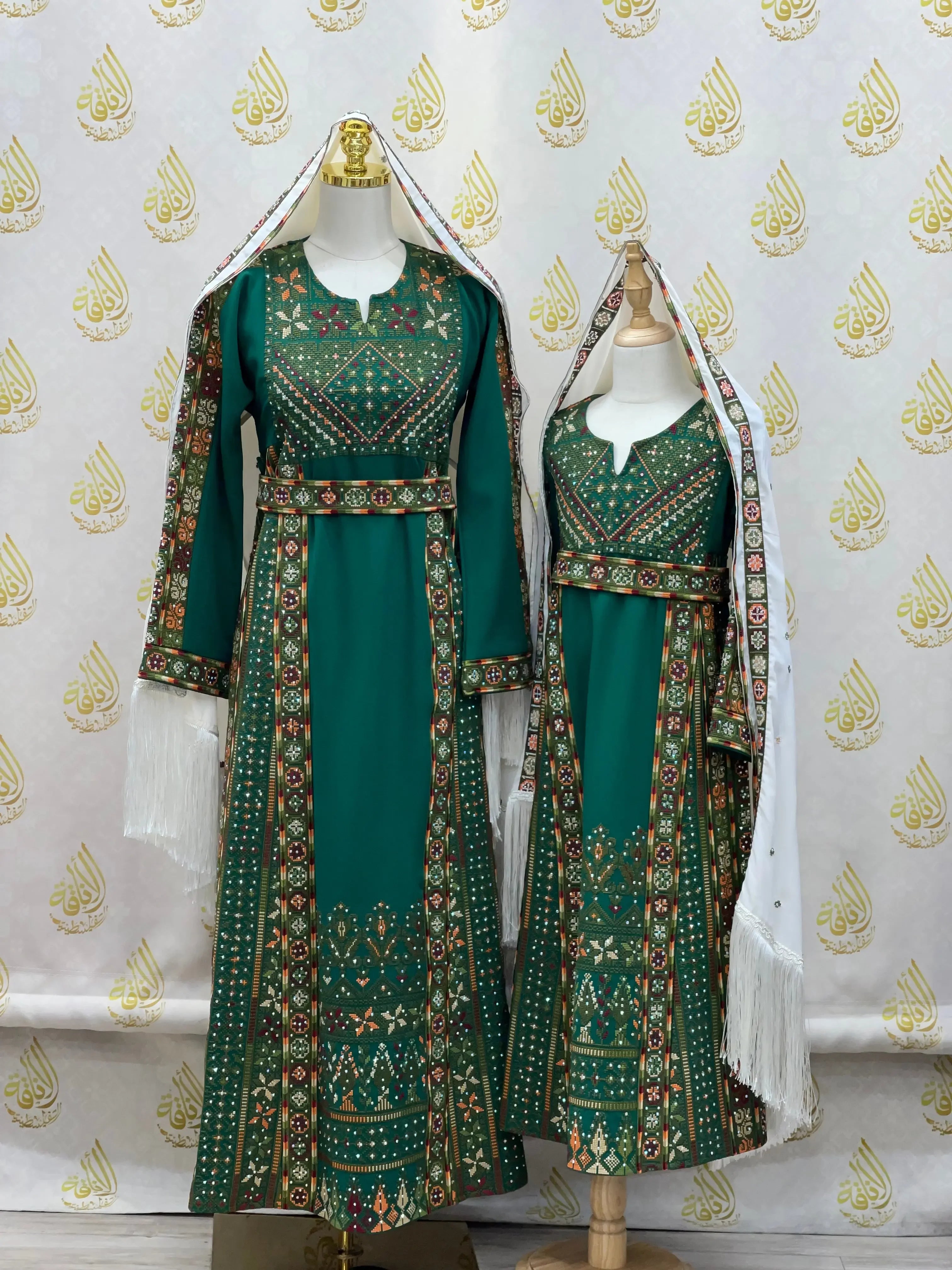 Green embroidered thoub for girls by Palestinian Elegance with intricate traditional patterns and white headscarves