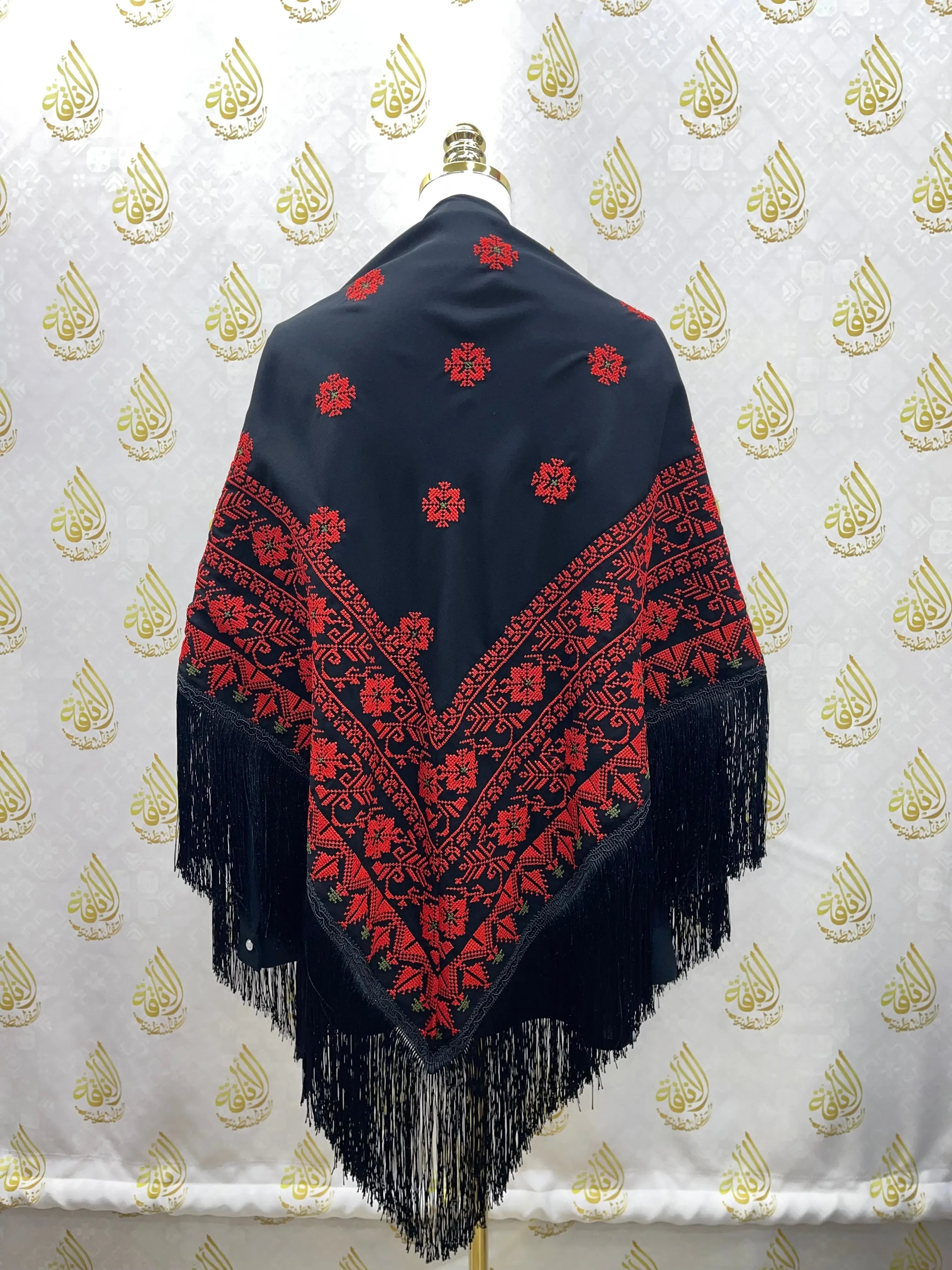 Palestinian Elegance embroidered triangle shawl with red traditional patterns on black fabric and fringe trim
