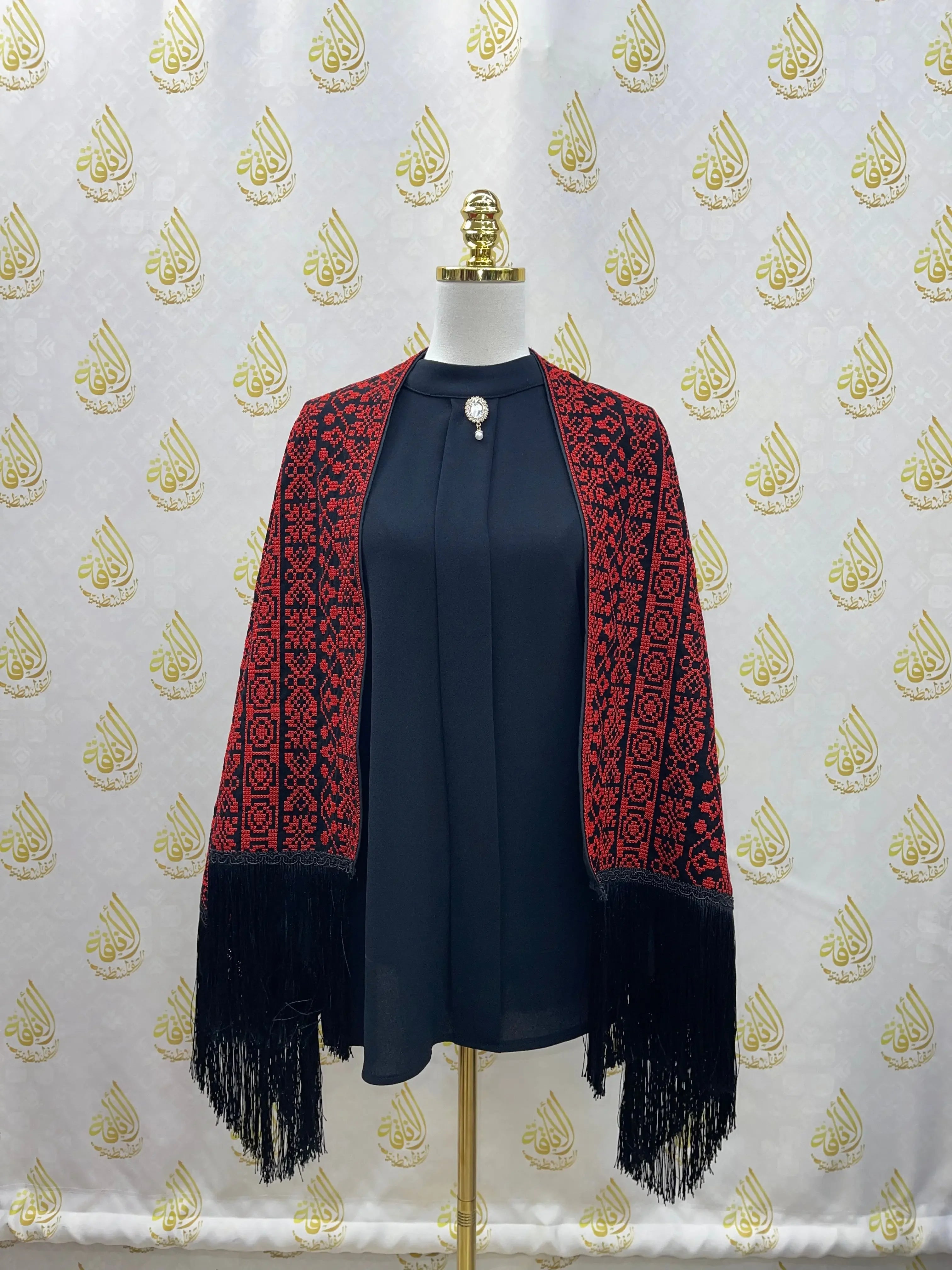 Palestinian Elegance embroidered triangle shawl in red and black with intricate patterns and fringed edges