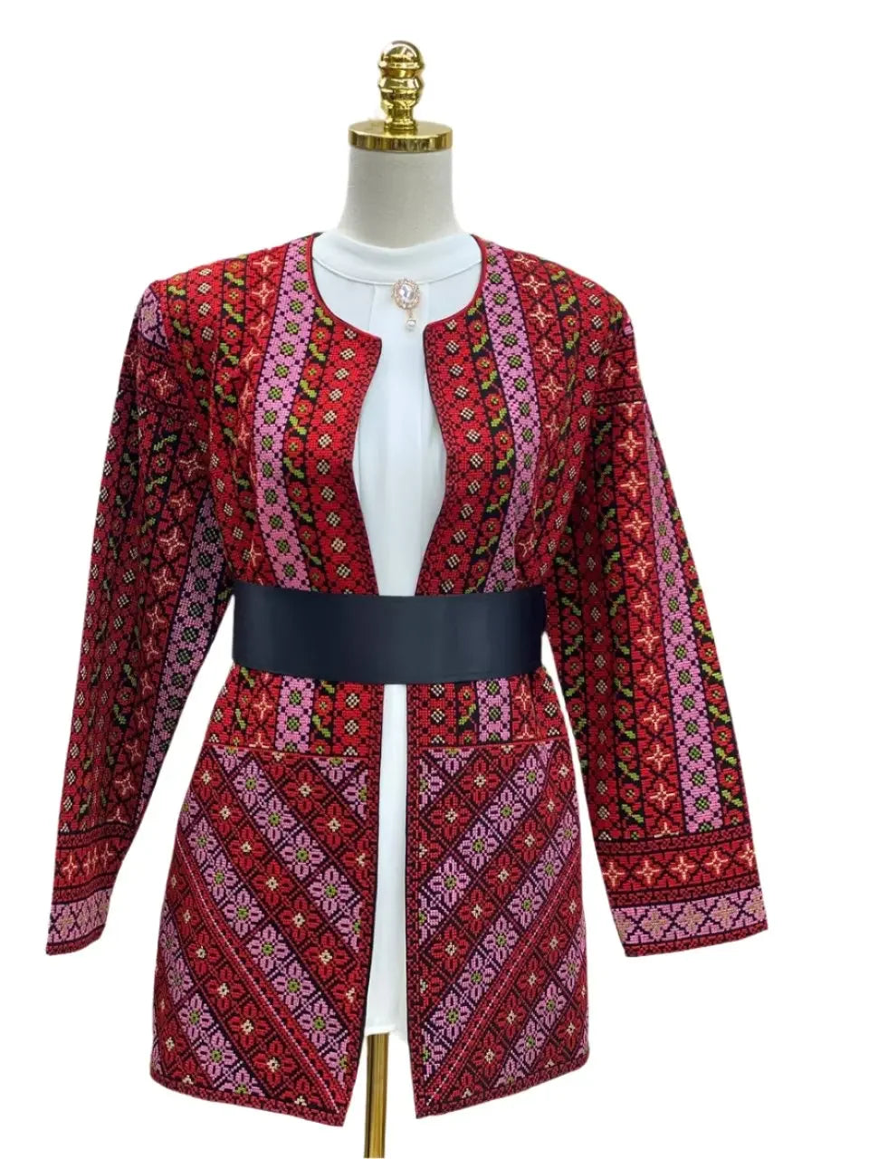 Palestinian Elegance embroidered women's jacket with red geometric patterns and black belt on mannequin