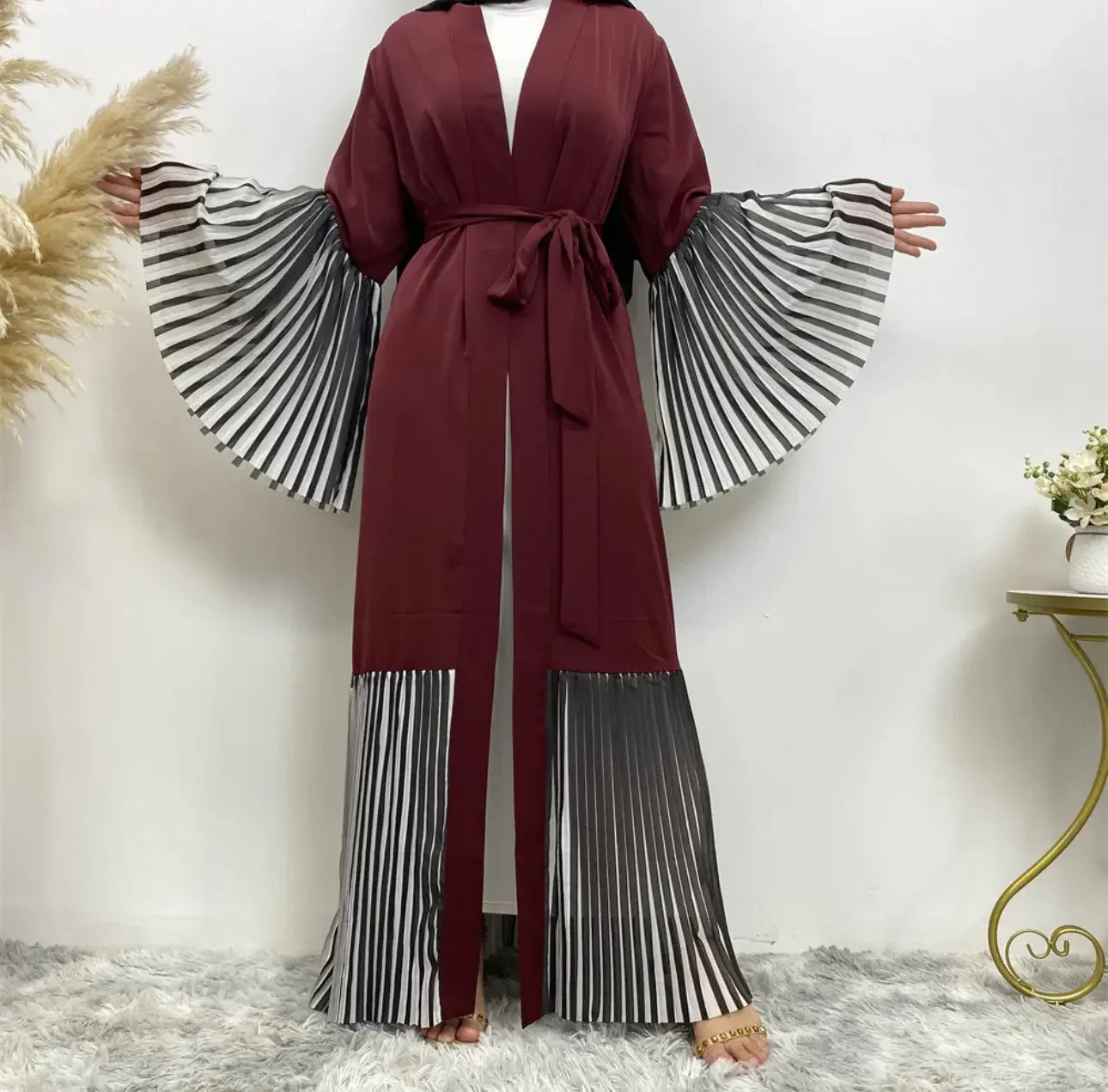 Palestinian Elegance flare sleeve abaya in maroon with black and white pleated sleeves and hem detailing