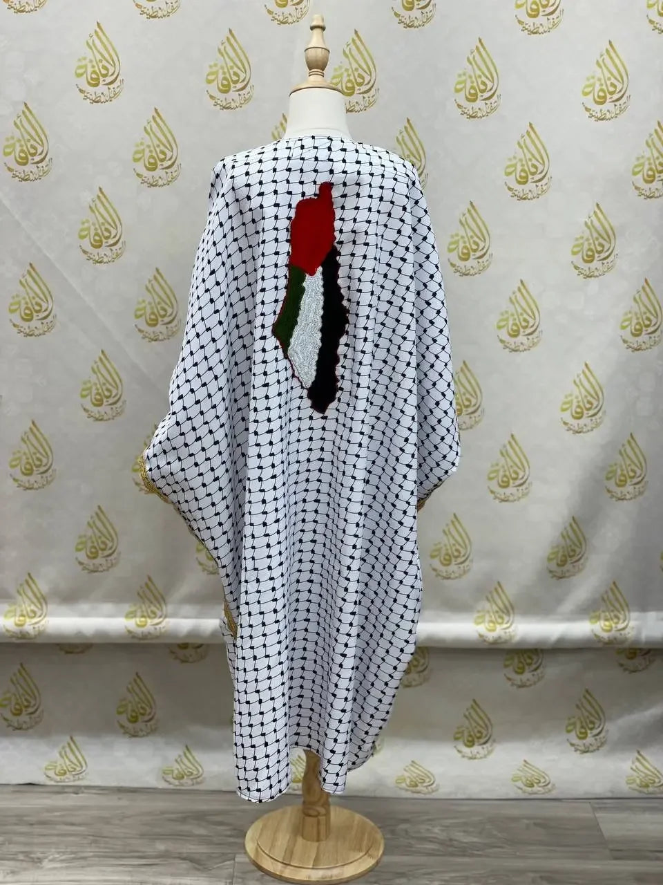 Girls kufiya bisht dress with traditional black and white checkered pattern and Palestinian flag embroidery