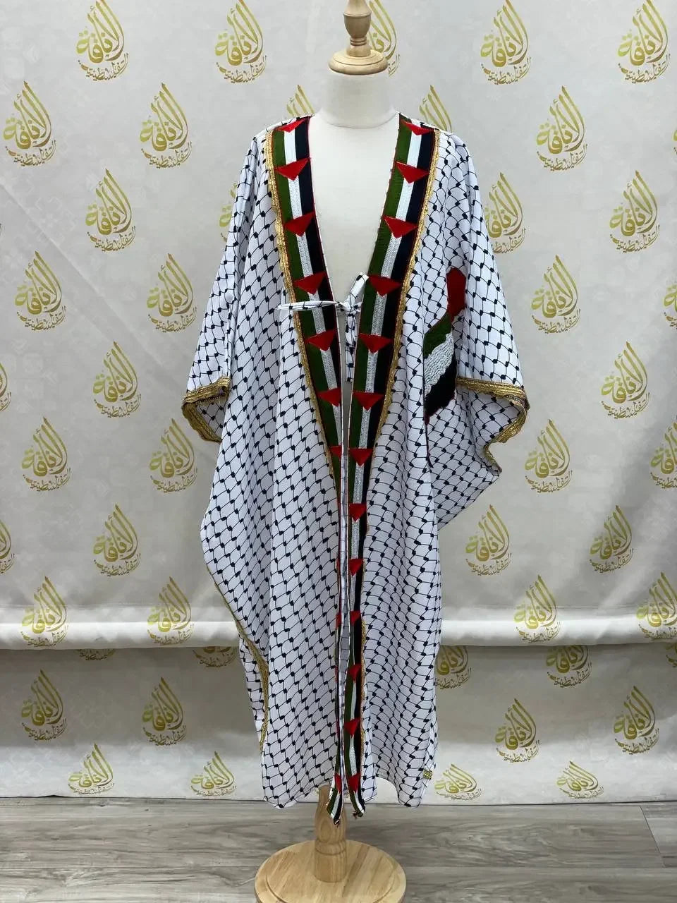Girls kufiya bisht dress with traditional Palestinian black and white pattern and colorful embroidered trim
