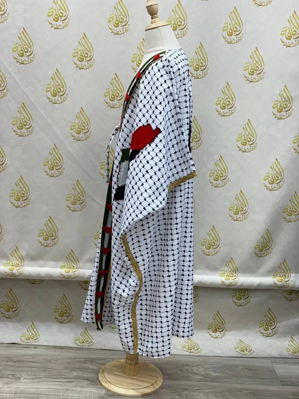 Palestinian Elegance girls kufiya bisht dress in white with traditional black and red embroidery on a mannequin