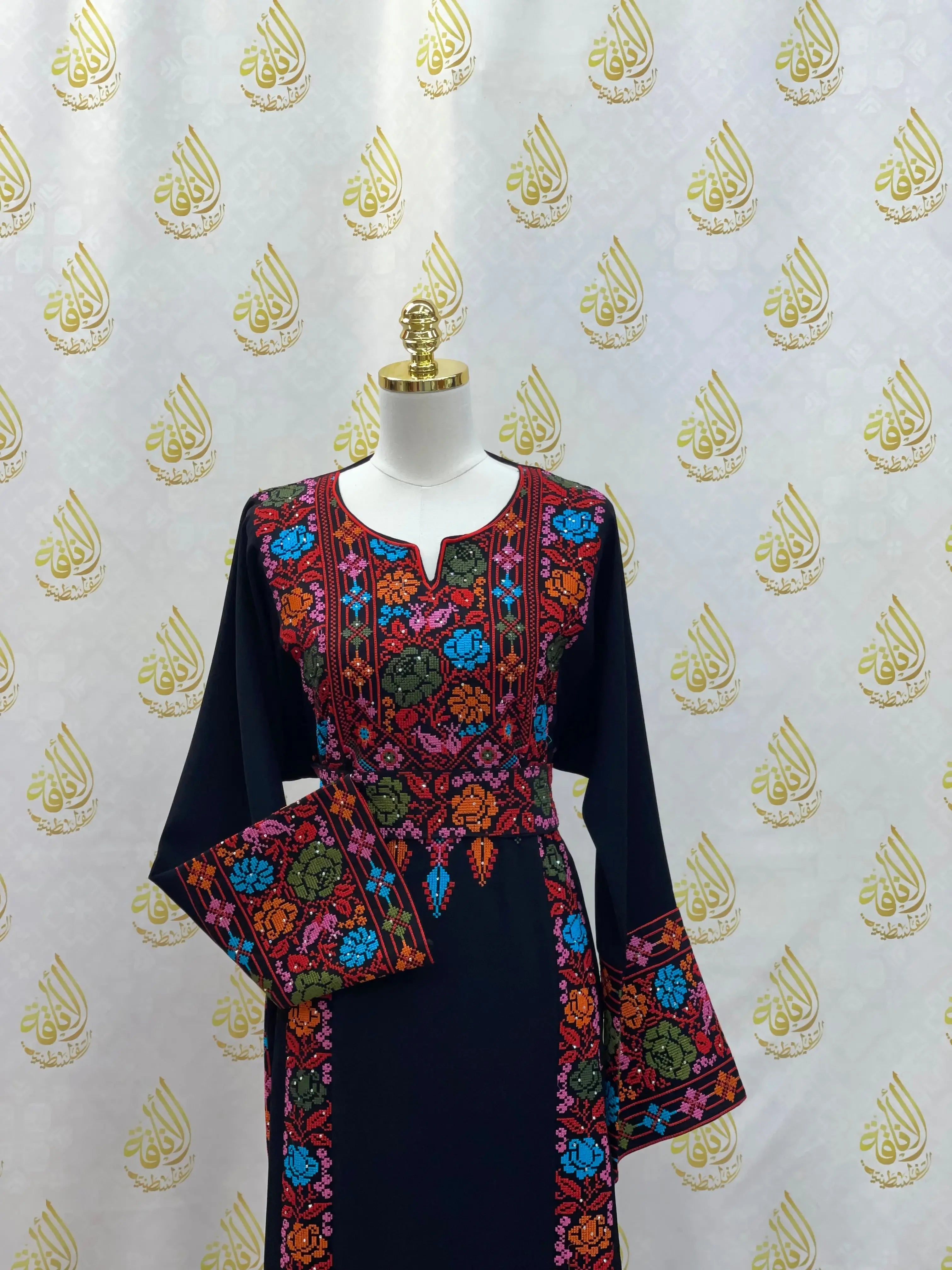 Palestinian Elegance hand-embroidered abaya in black with vibrant floral embroidery on sleeves and chest