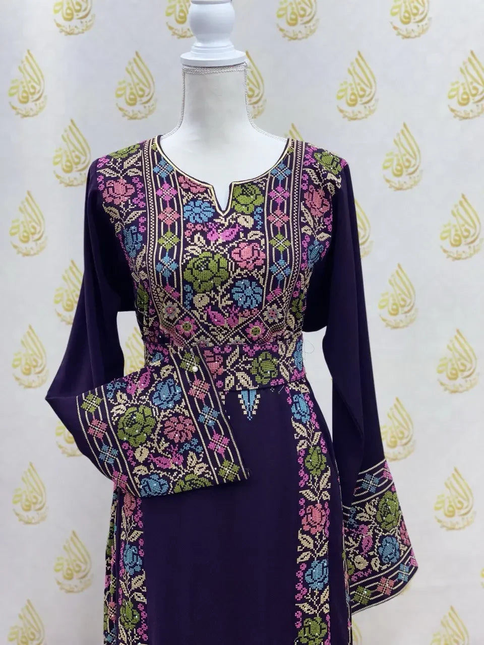 Palestinian Elegance hand-embroidered abaya in dark purple with colorful floral embroidery on chest and sleeves