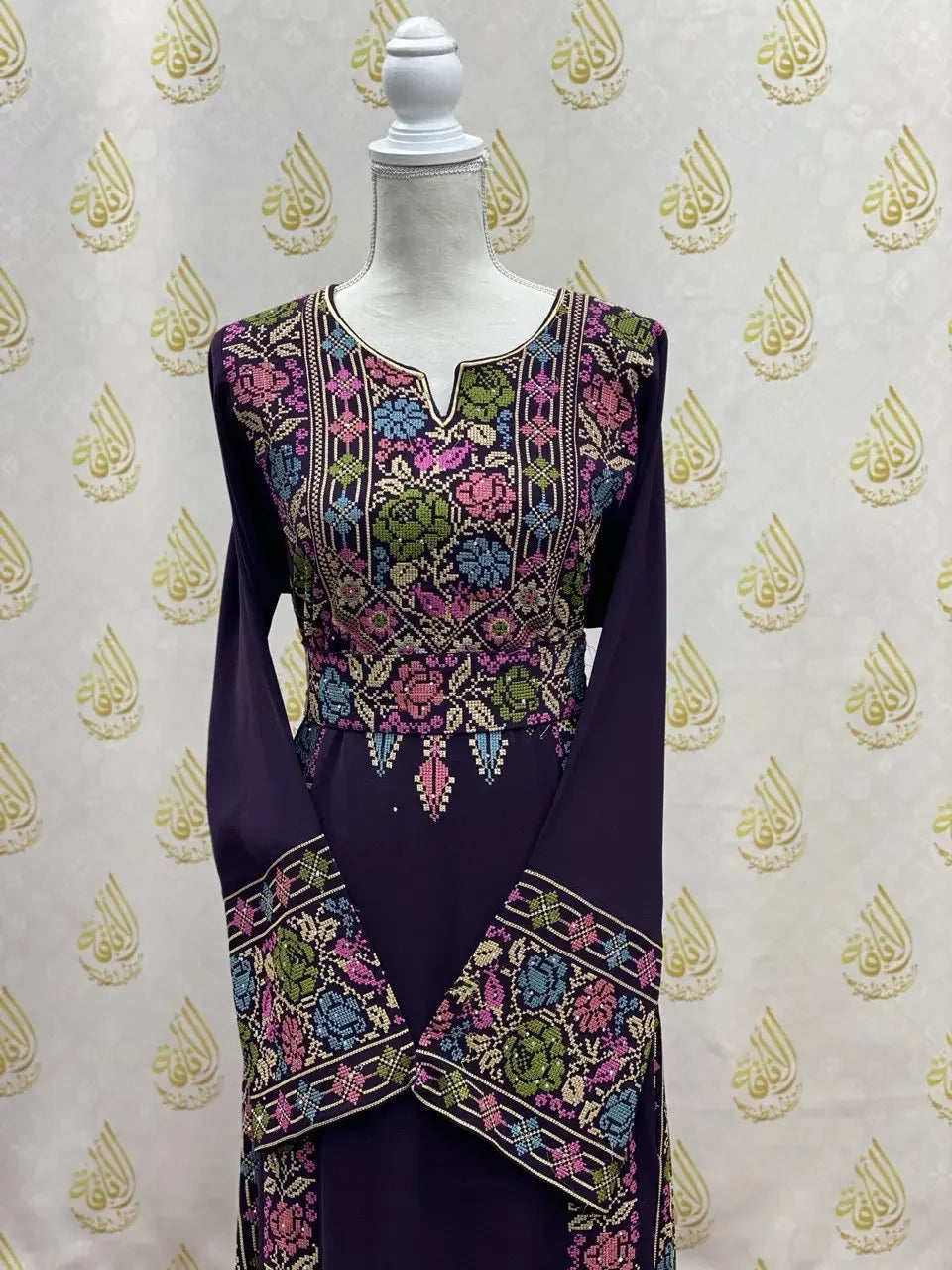 Palestinian Elegance hand-embroidered abaya with intricate colorful floral embroidery on purple fabric