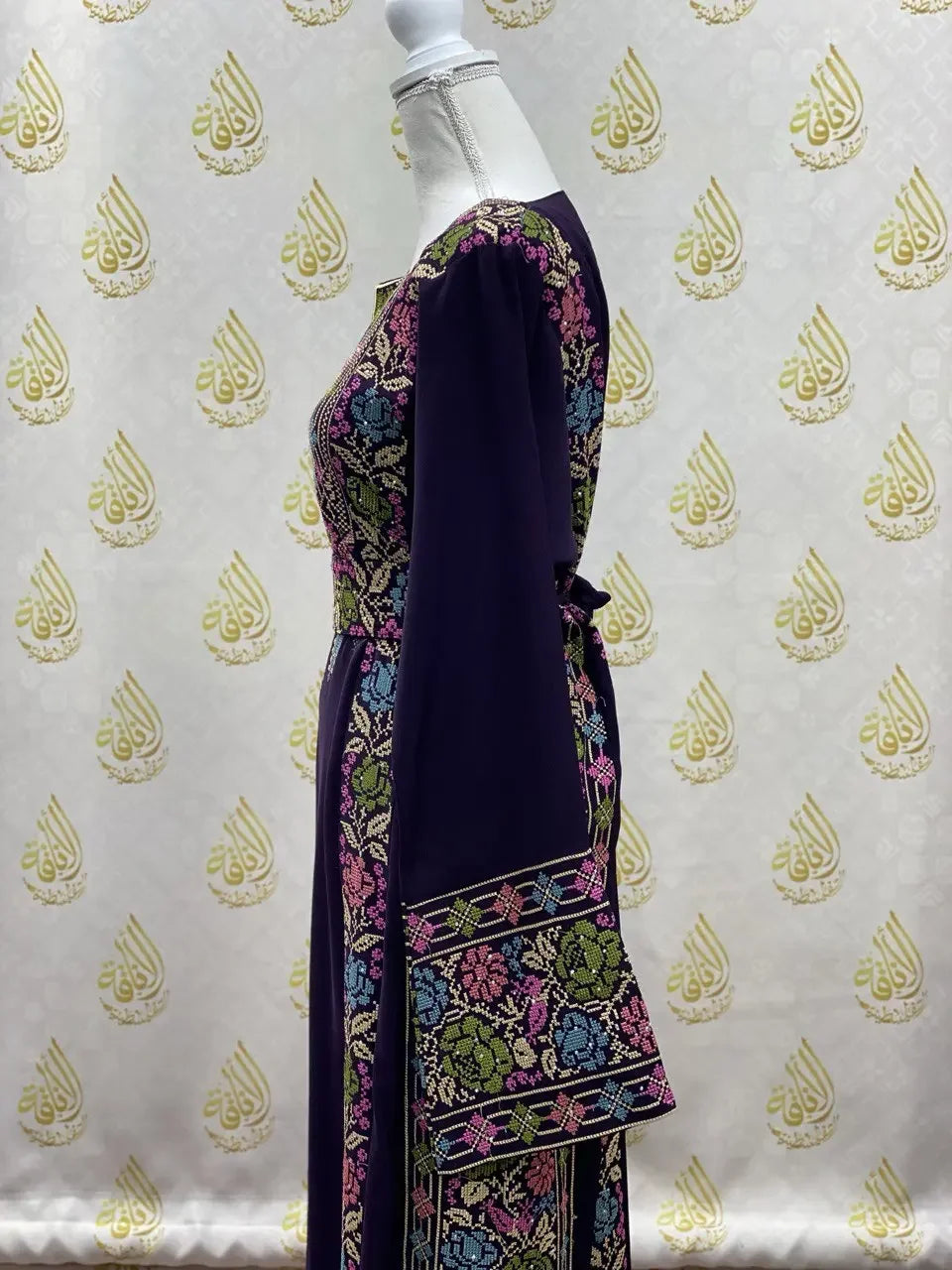 Palestinian Elegance hand-embroidered abaya in dark fabric with colorful floral embroidery on sleeves and bodice