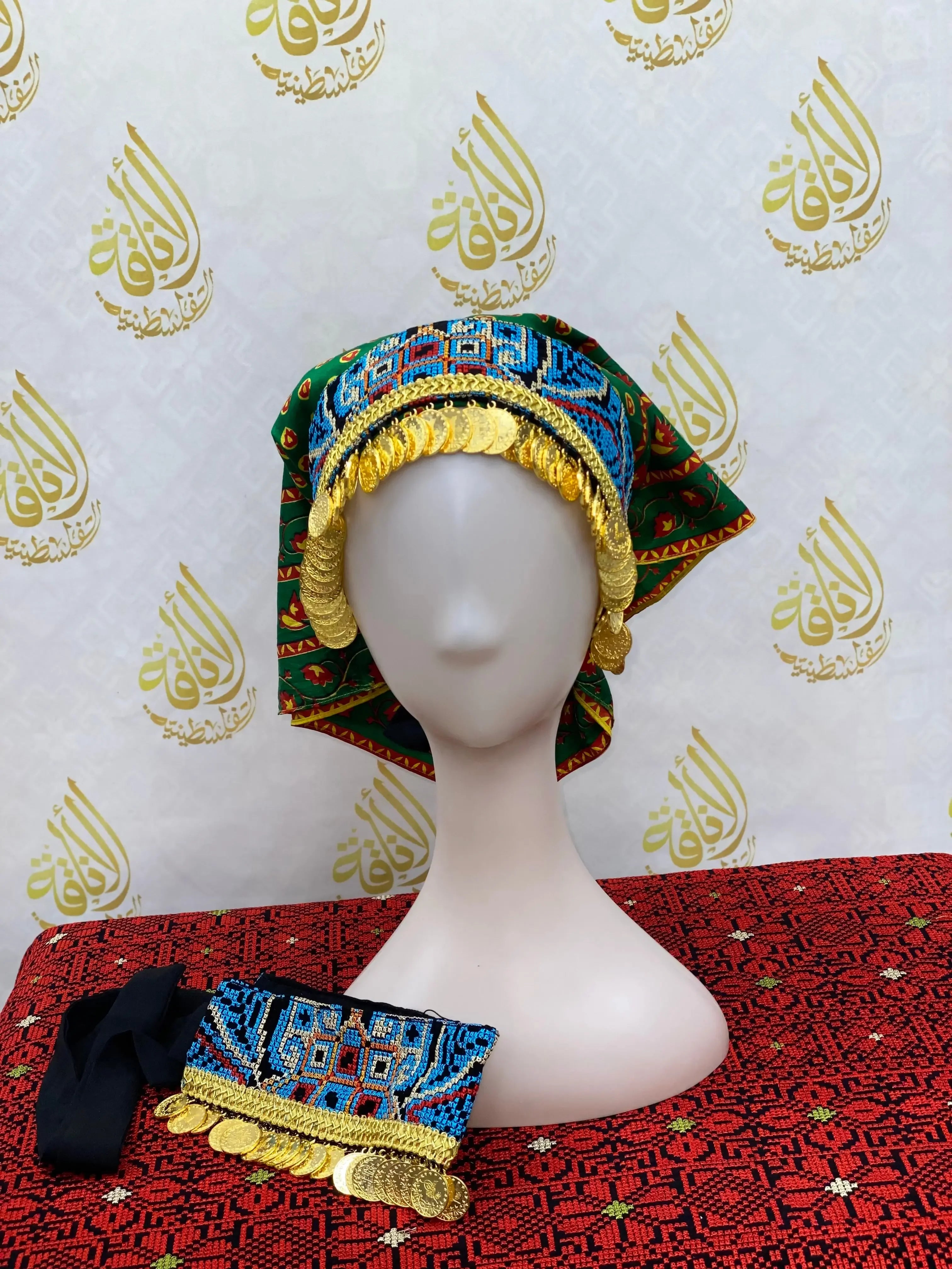 Hand embroidered tatreez headscarf with blue patterns and gold coin accents displayed on a mannequin