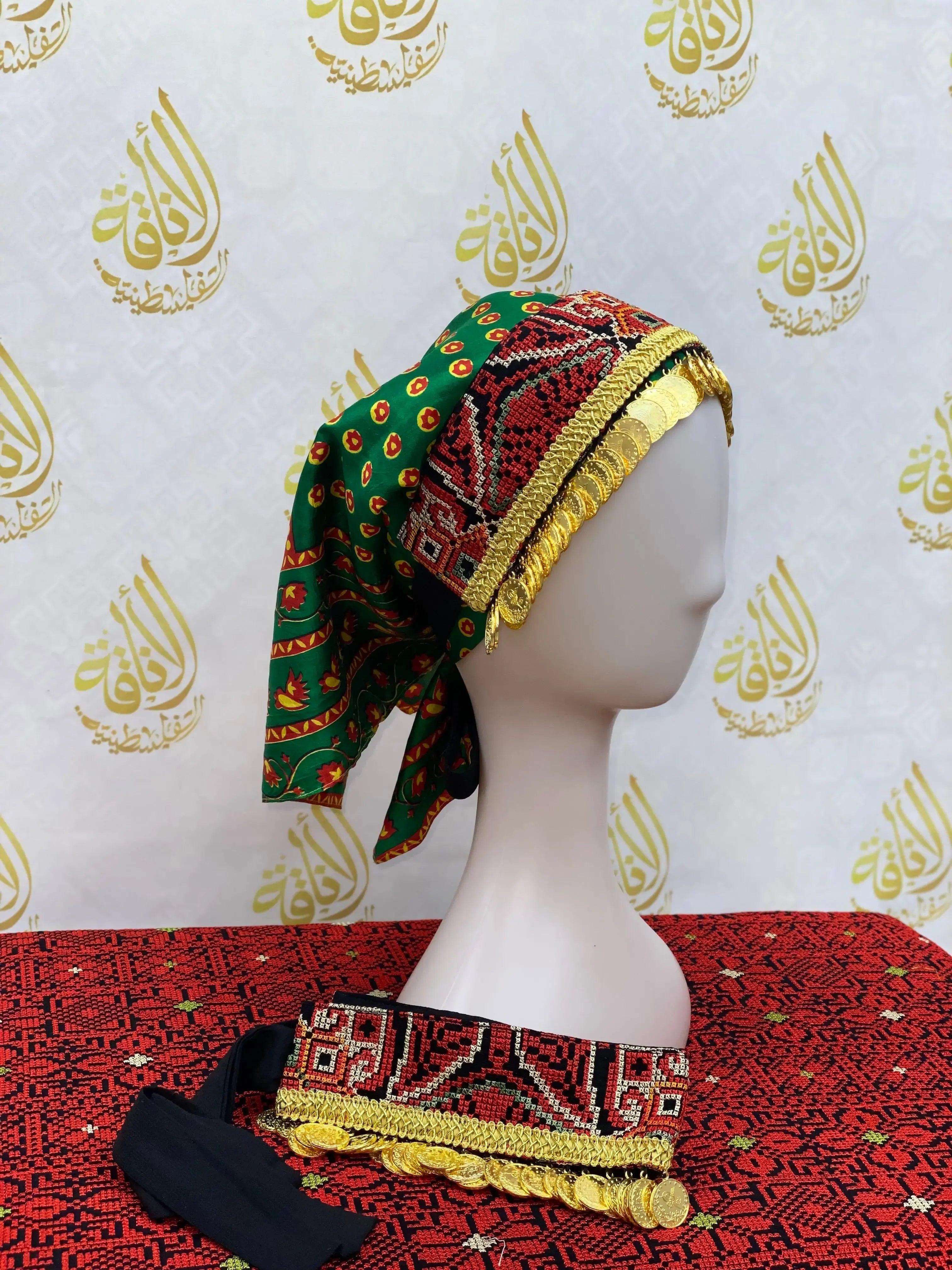 Hand embroidered tatreez headscarf in green and red with gold detailing from Palestinian Elegance