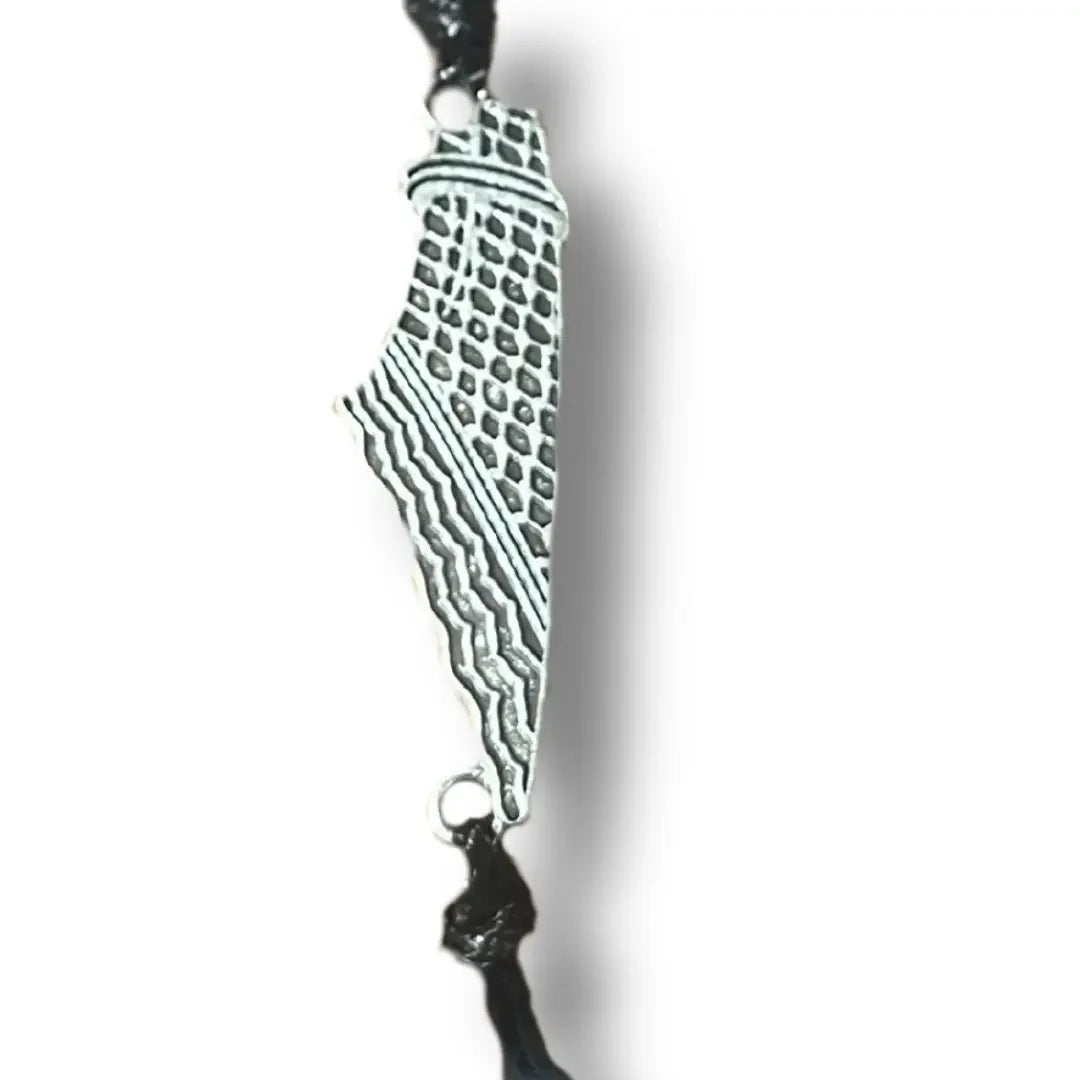 Close-up of a handcrafted Palestine bracelet featuring a silver-tone map design on a black cord