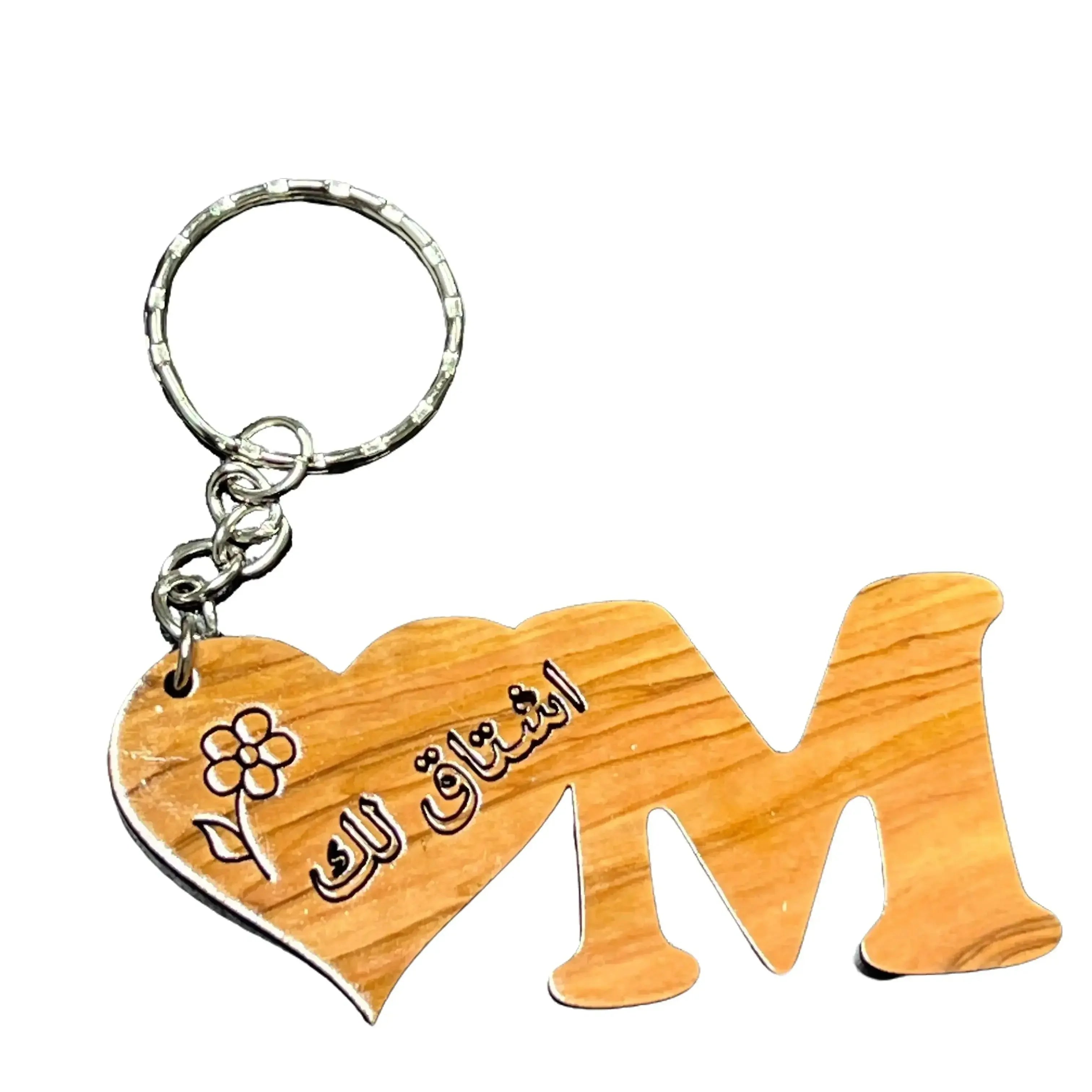 Handmade Arabic keychain with wooden heart and letter M featuring Arabic calligraphy and flower design