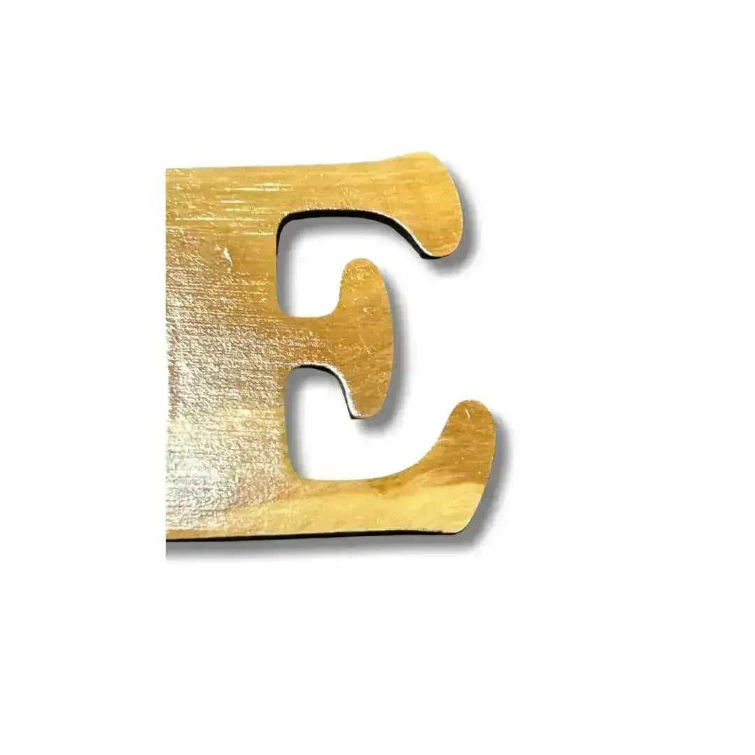 Close-up of a golden wooden letter E from a handmade Arabic love keychain by Palestinian Elegance