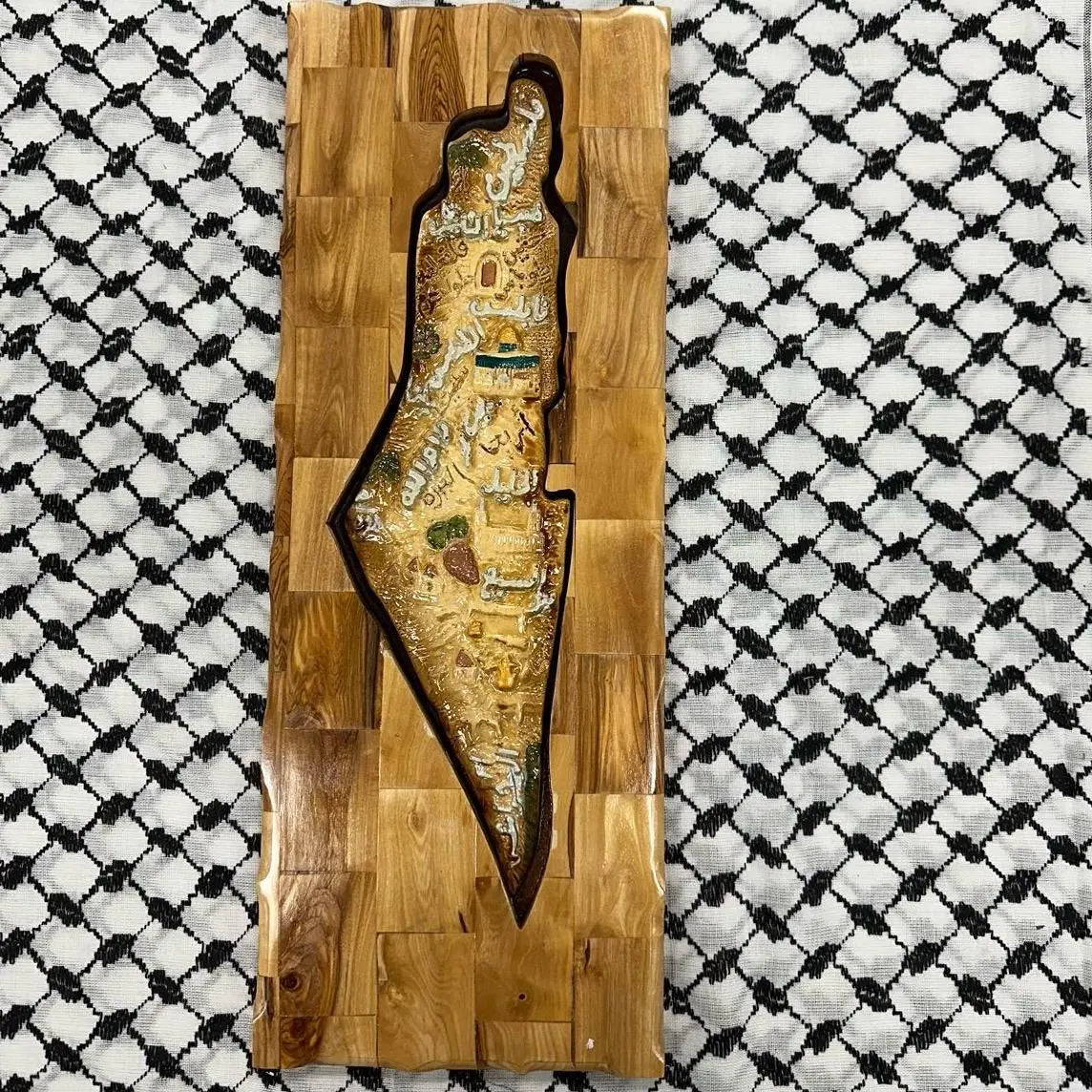 Handmade Palestinian wooden frame featuring detailed map design on traditional fabric background