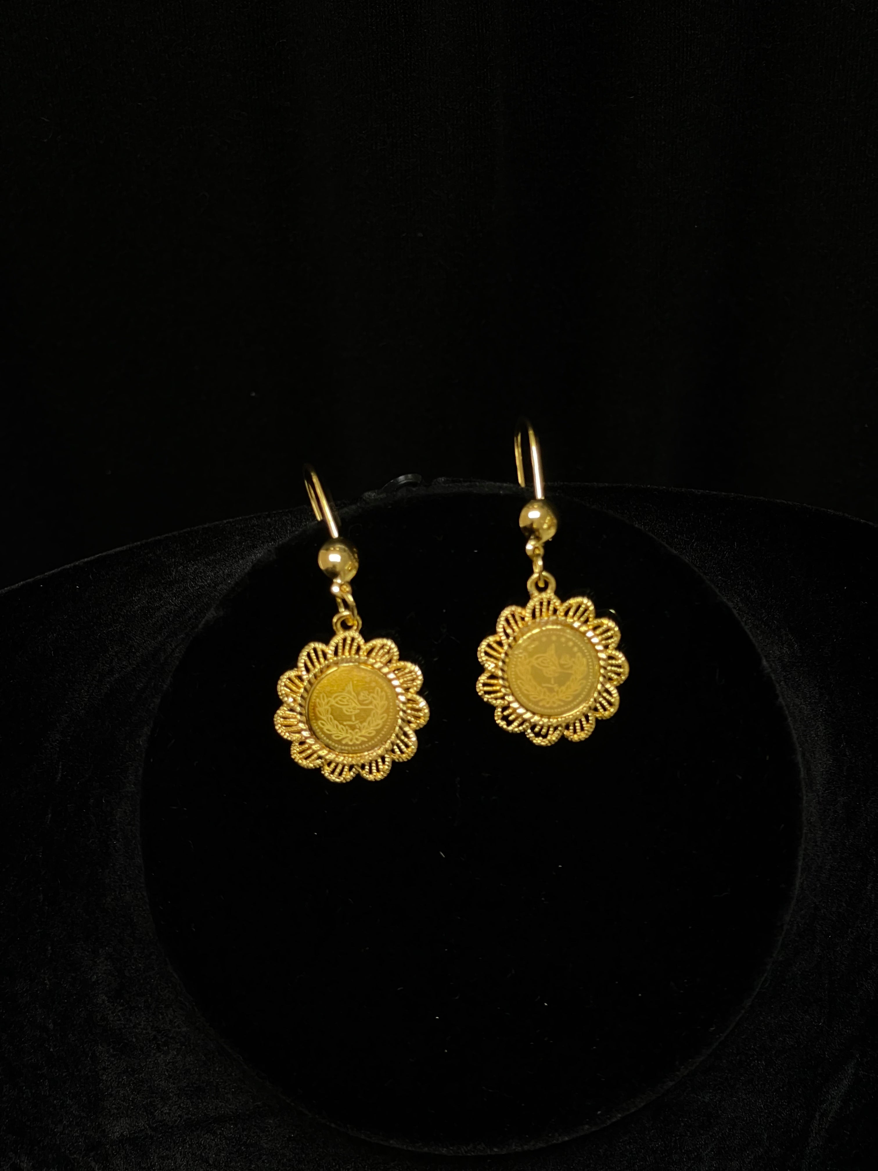 Palestinian Elegance imitated gold jewelry set featuring floral design gold earrings on black display