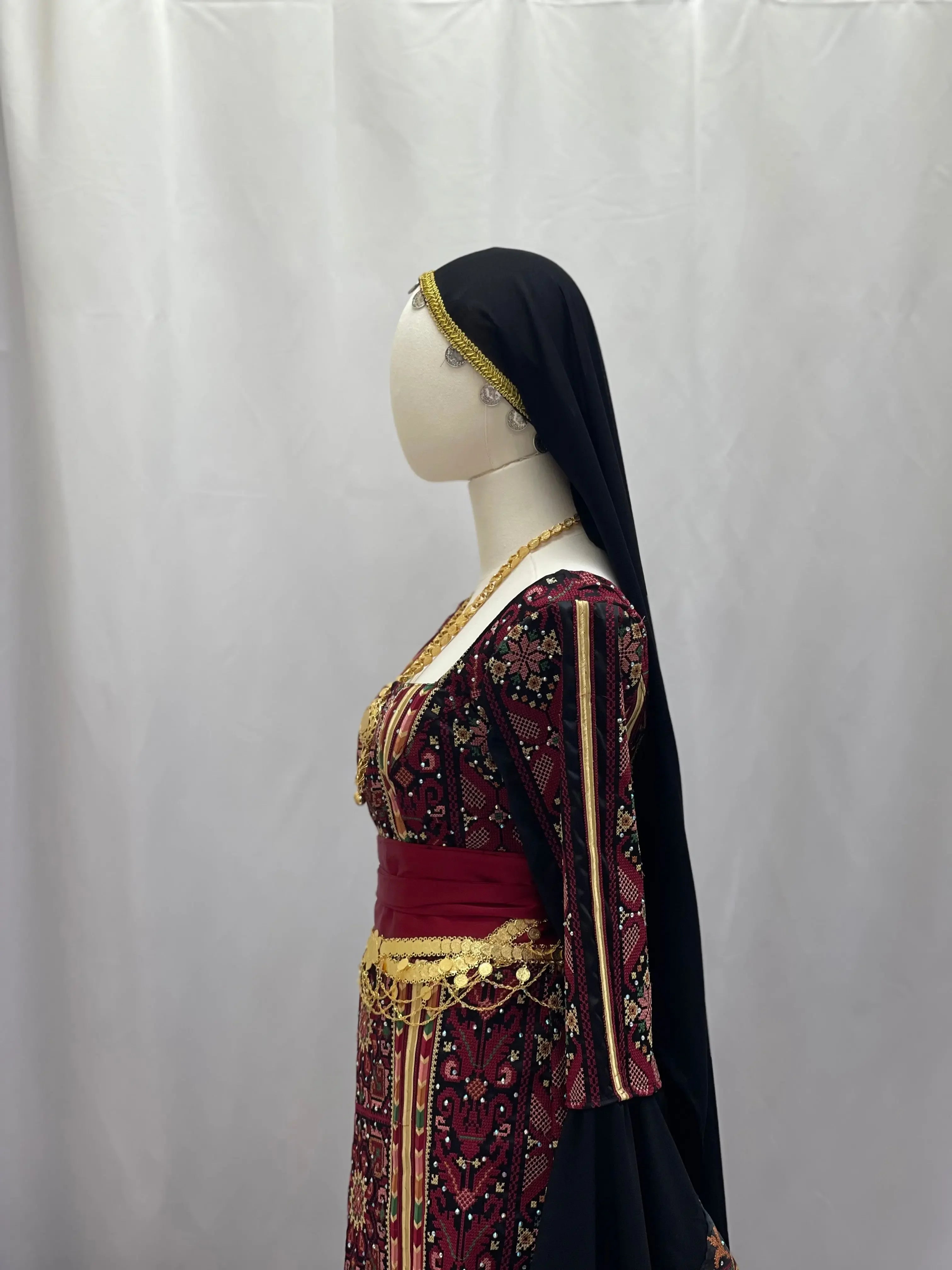 Palestinian Elegance traditional khirka with gold coins accessory worn with embroidered dress and black headscarf