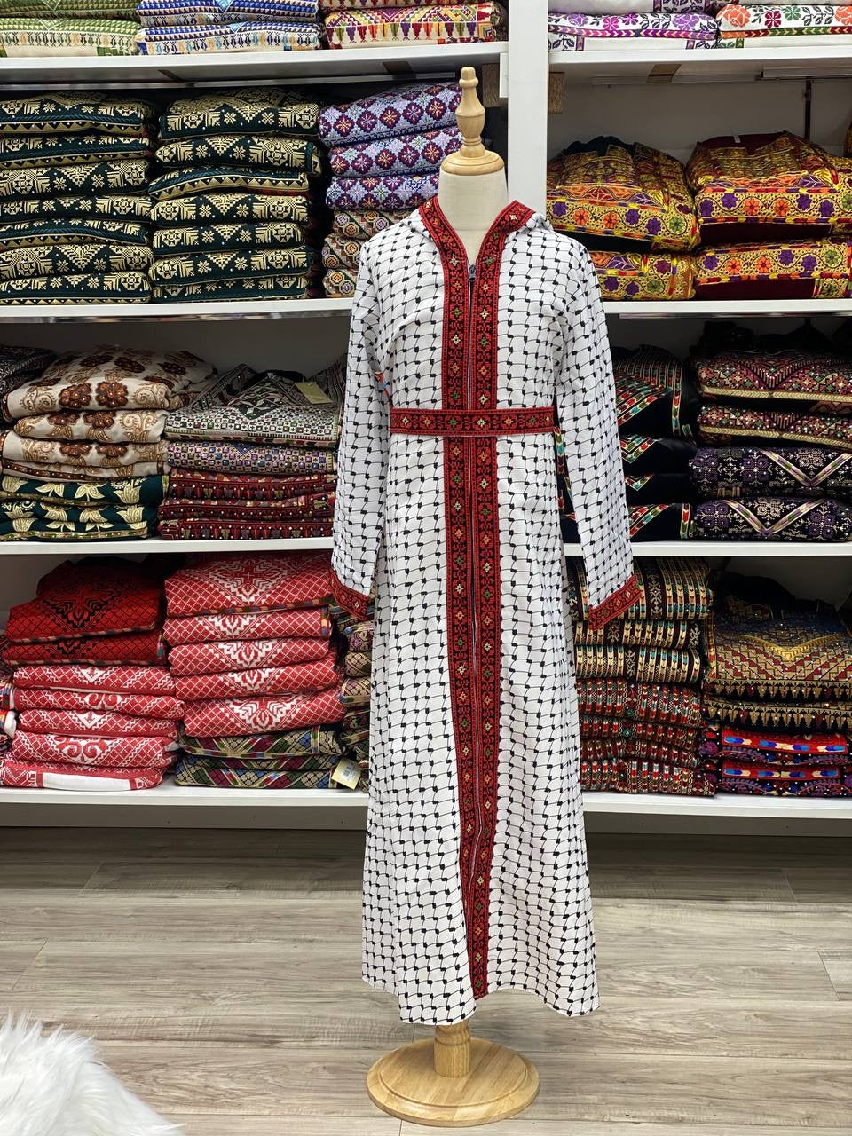 Kids embroidered bisht in white with traditional red and black embroidery displayed on a mannequin