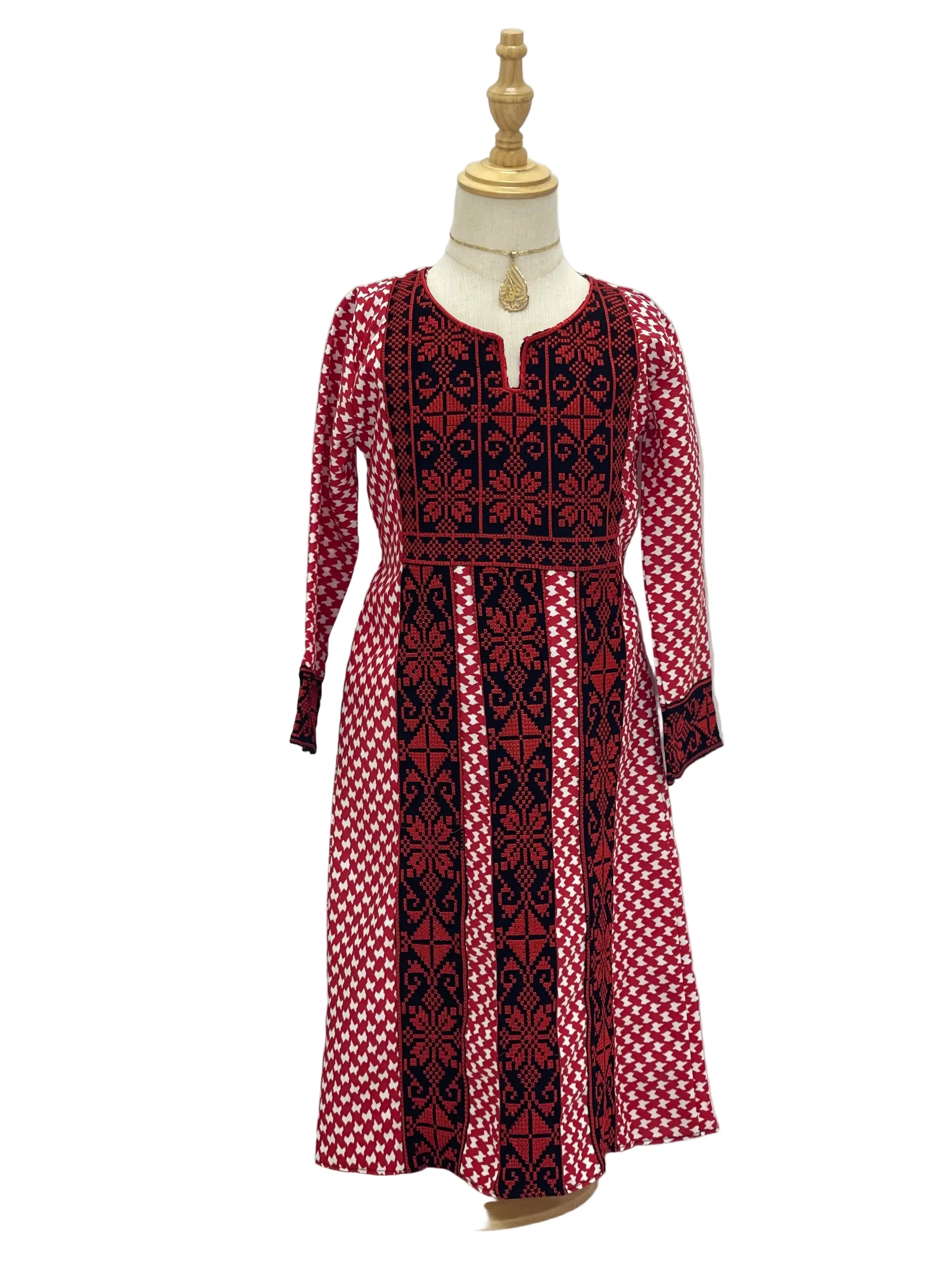 Kids embroidered Palestinian dress in red and black with traditional geometric patterns displayed on mannequin