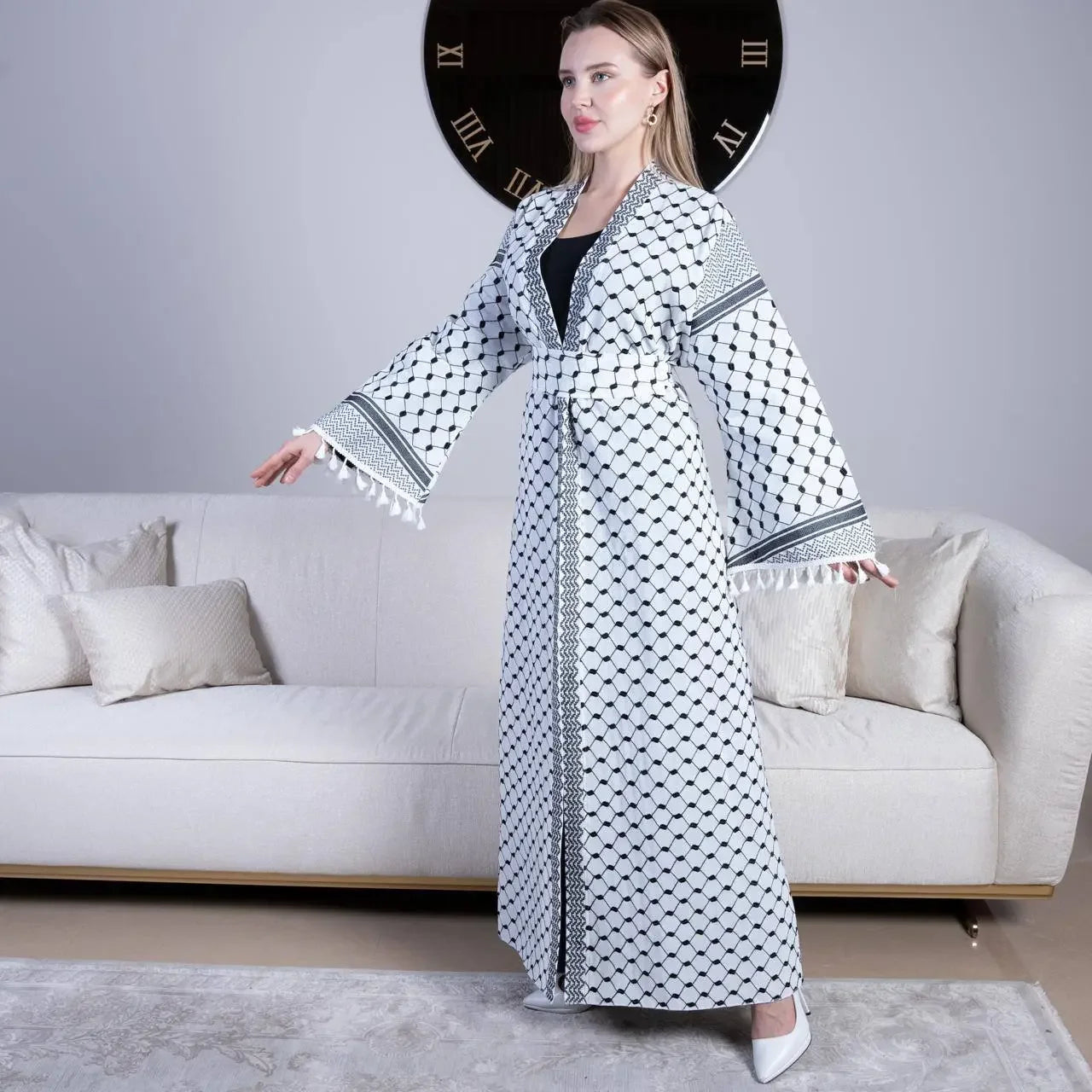Woman wearing a kuffiyeh embroidery cardigan with traditional black and white patterns and tassel details