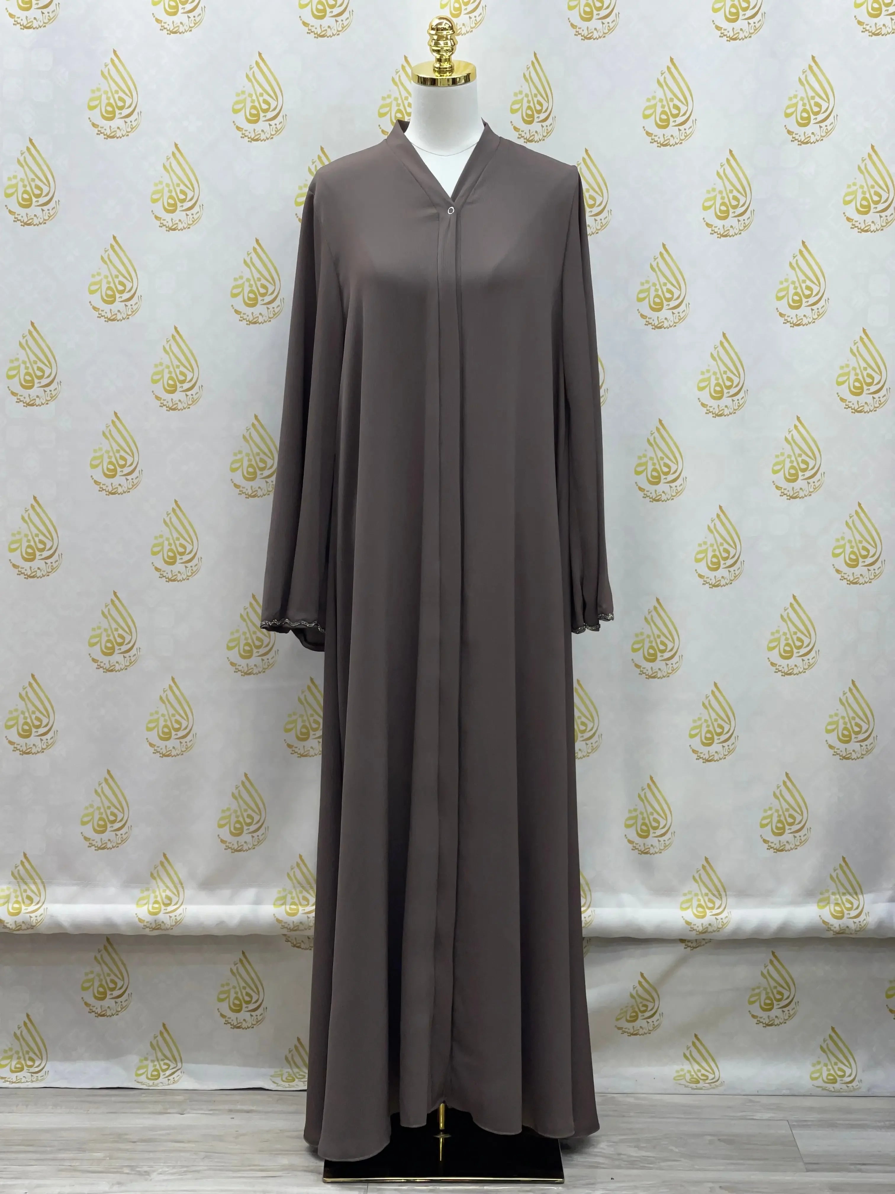 Palestinian Elegance luxurious cloche cut abaya in solid brown with long sleeves on mannequin