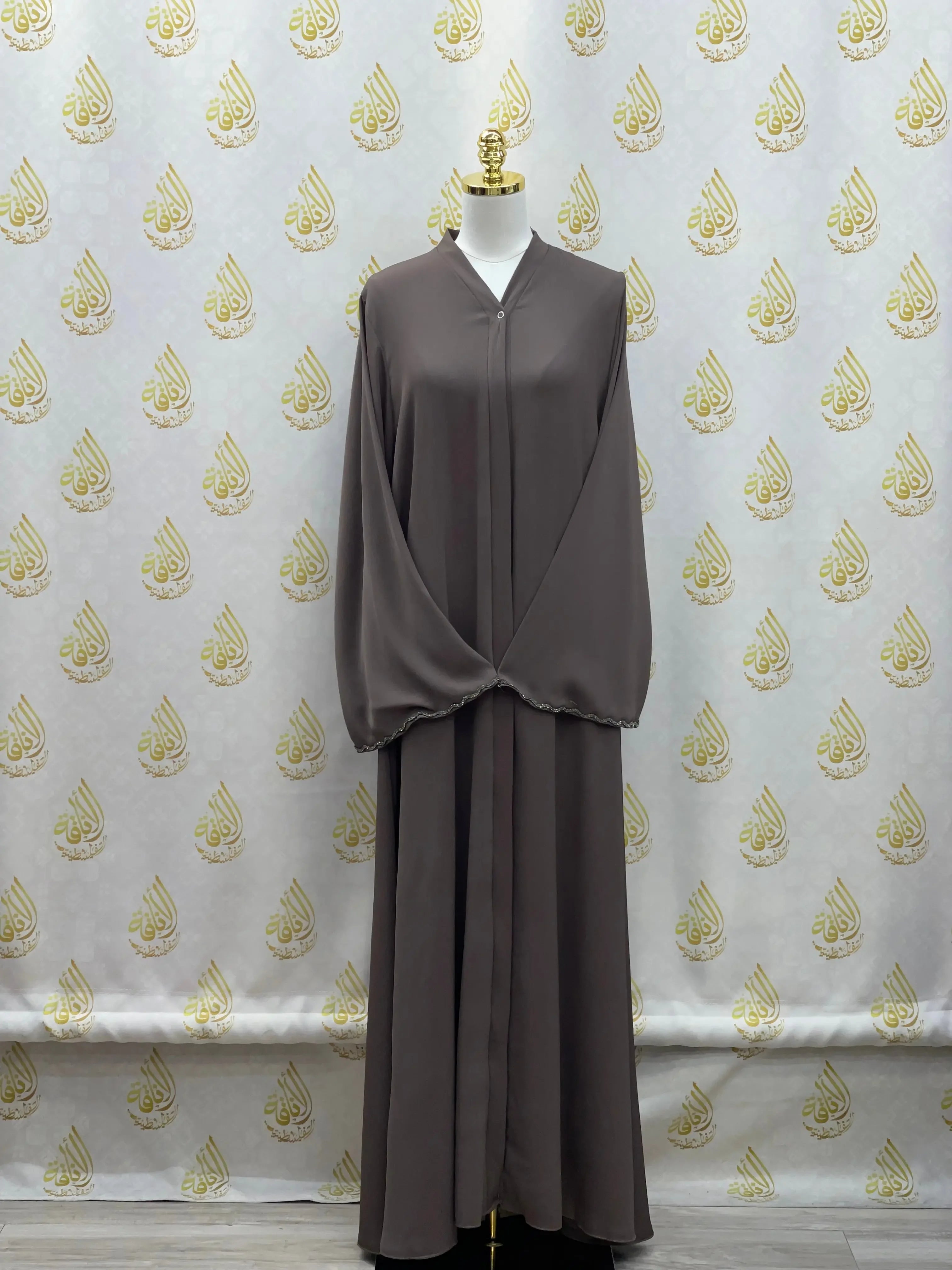 Palestinian Elegance luxurious cloche cut abaya in taupe with full-length draped sleeves on mannequin