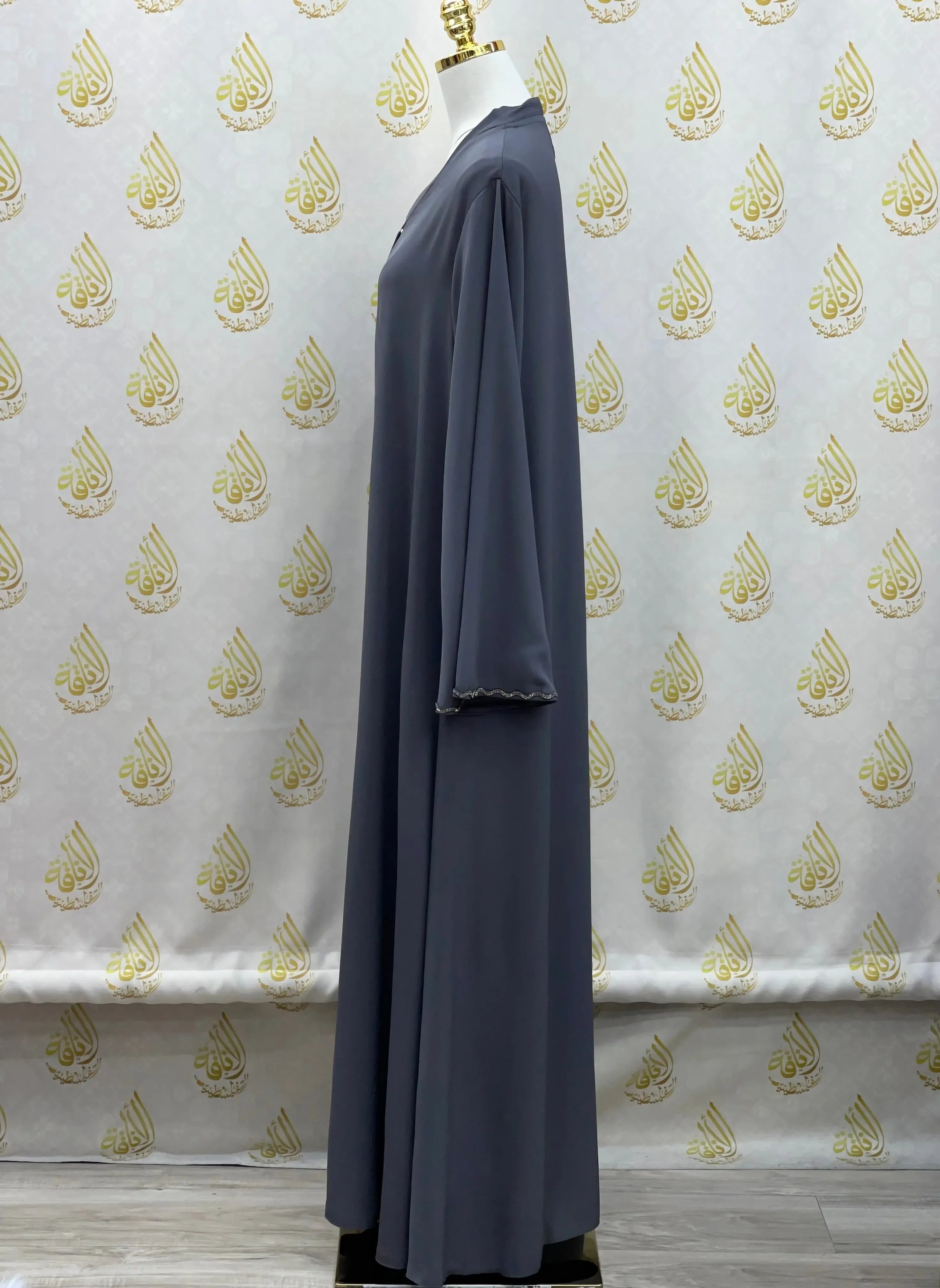 Side view of a gray luxurious cloche cut abaya from Palestinian Elegance on a mannequin