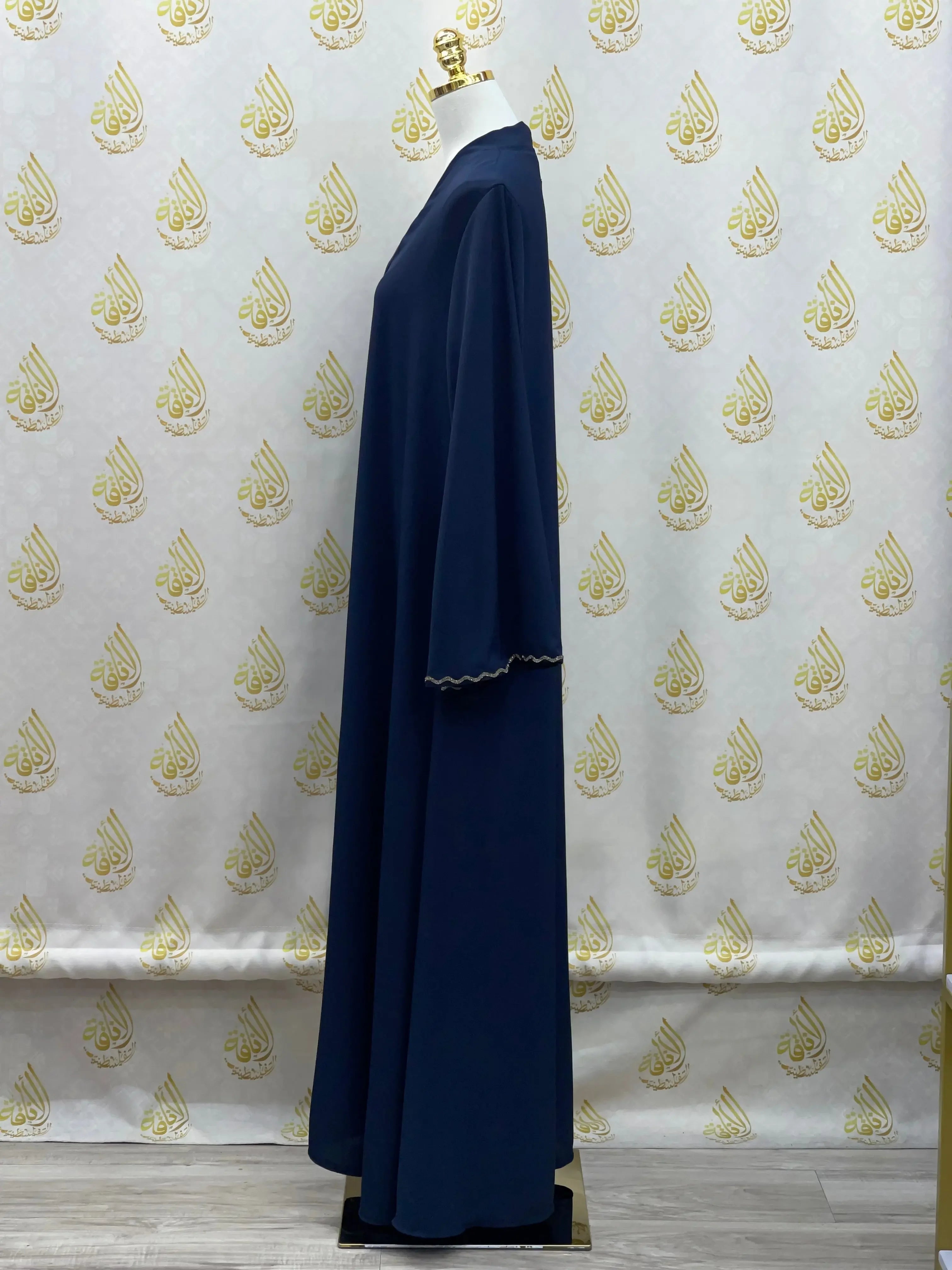 Palestinian Elegance luxurious cloche cut abaya in navy blue with scalloped sleeve edges on mannequin