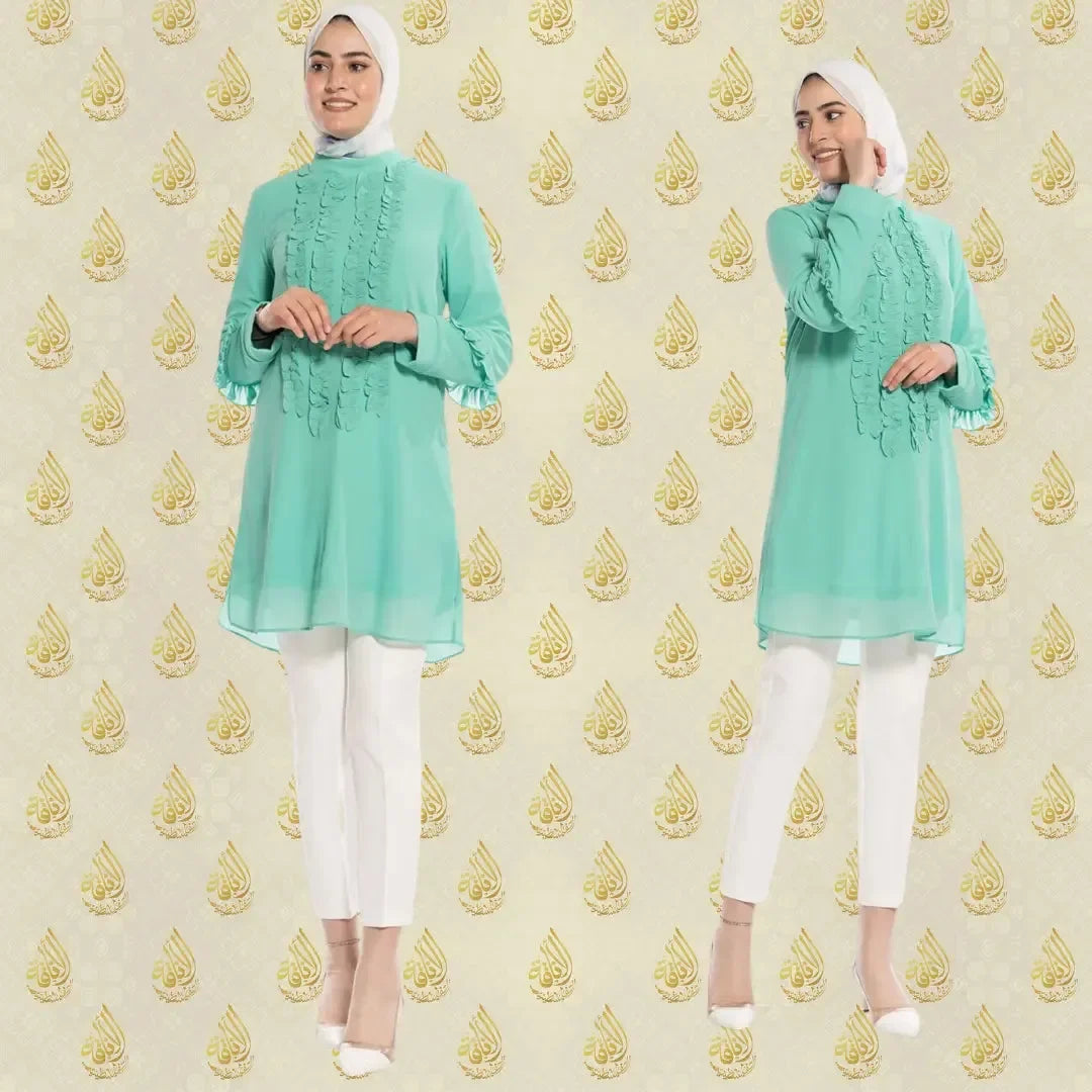 Luxury women's embroidered shirt in mint green paired with white pants by Palestinian Elegance