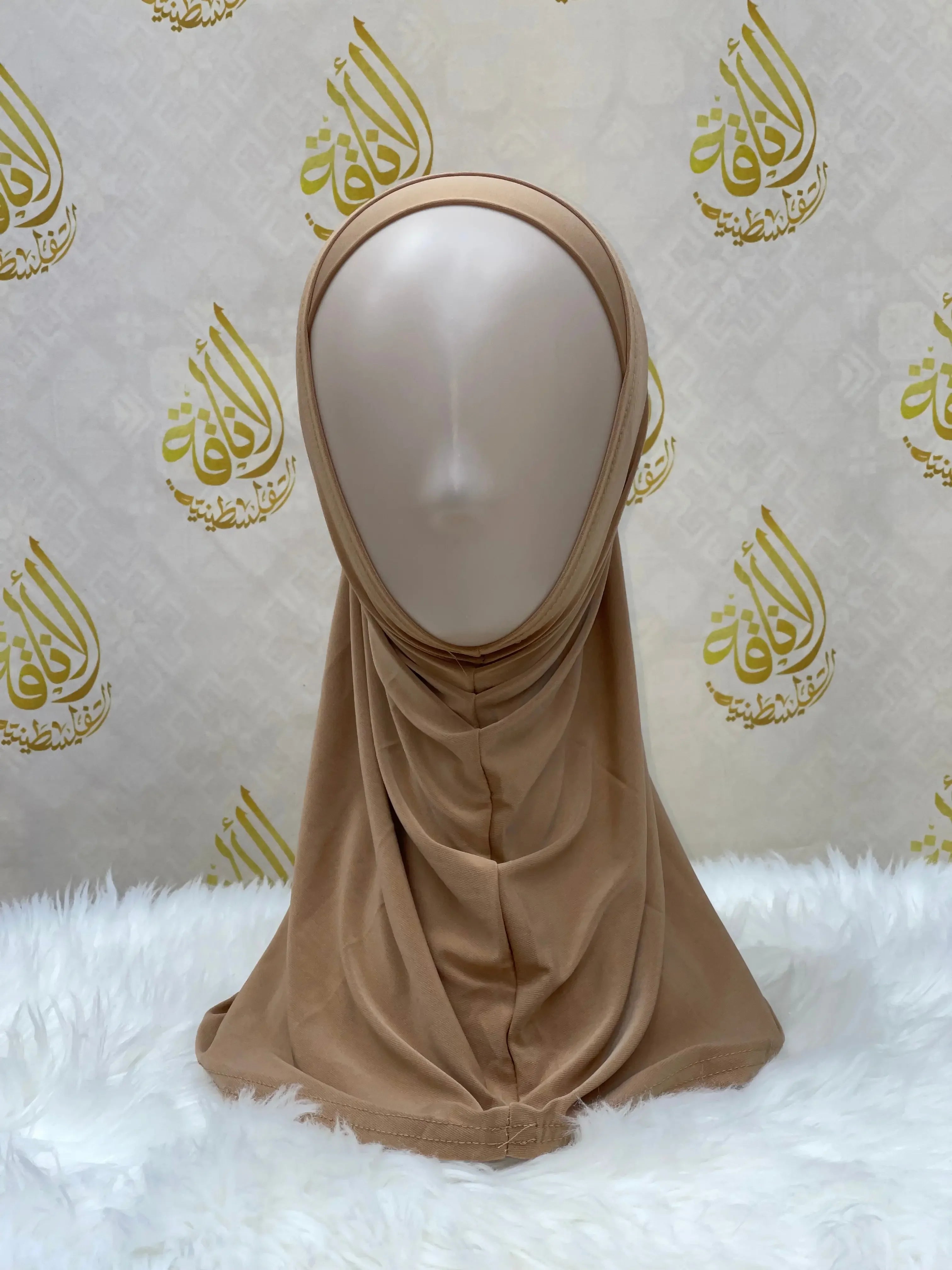 Beige lycra hijab for women displayed on a mannequin with Palestinian Elegance branding backdrop