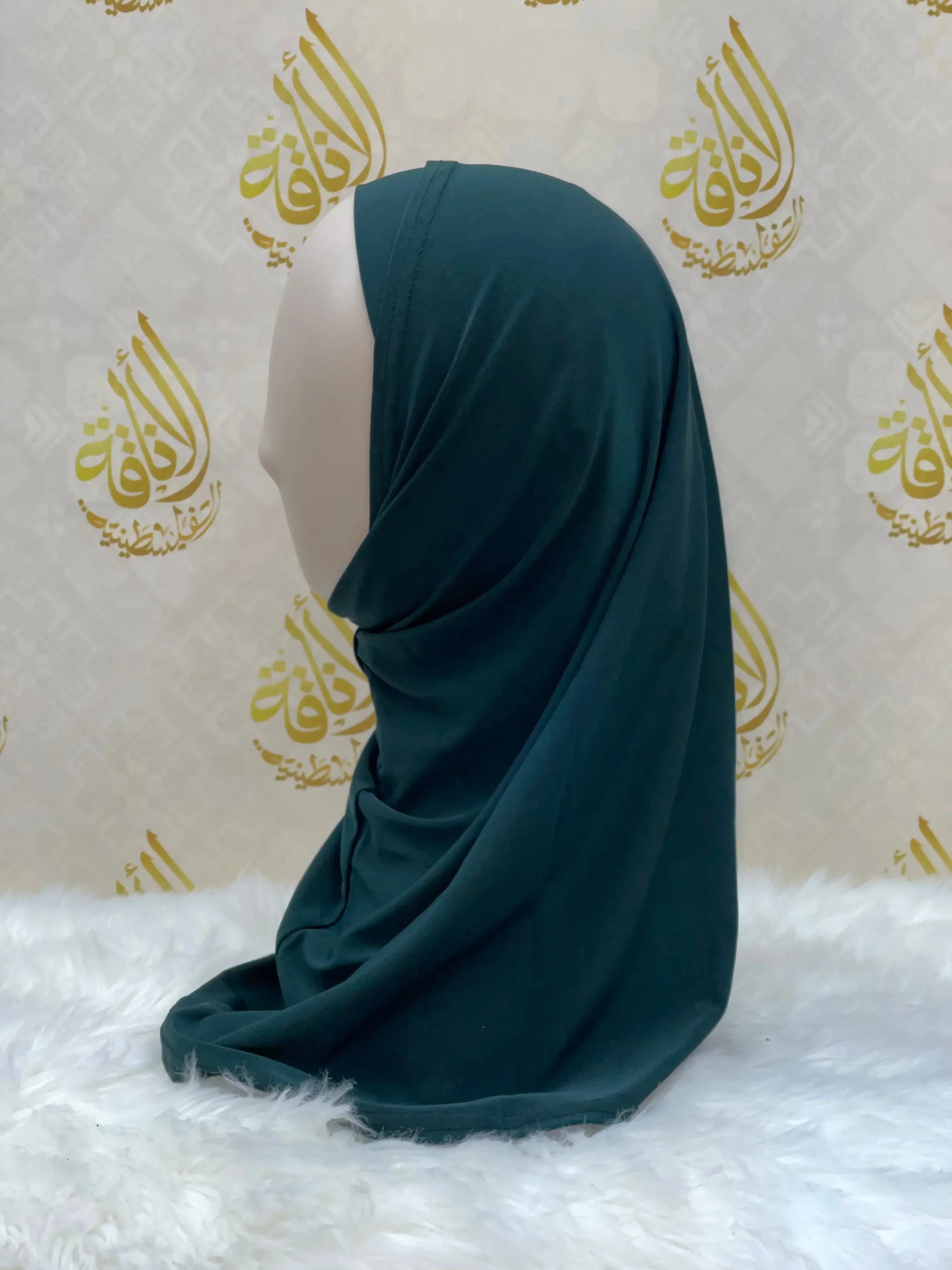 Dark green lycra hijab for women displayed on mannequin by Palestinian Elegance