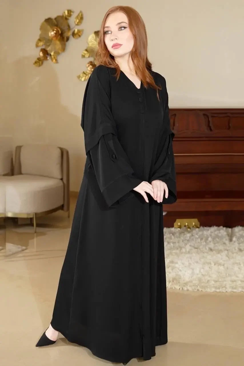 Palestinian Elegance black modern button abaya worn by model with long sleeves and button details