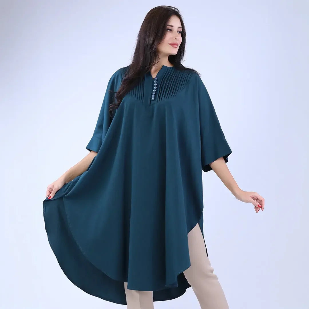 Woman wearing a teal modest cape top with button and pleated detail from Palestinian Elegance