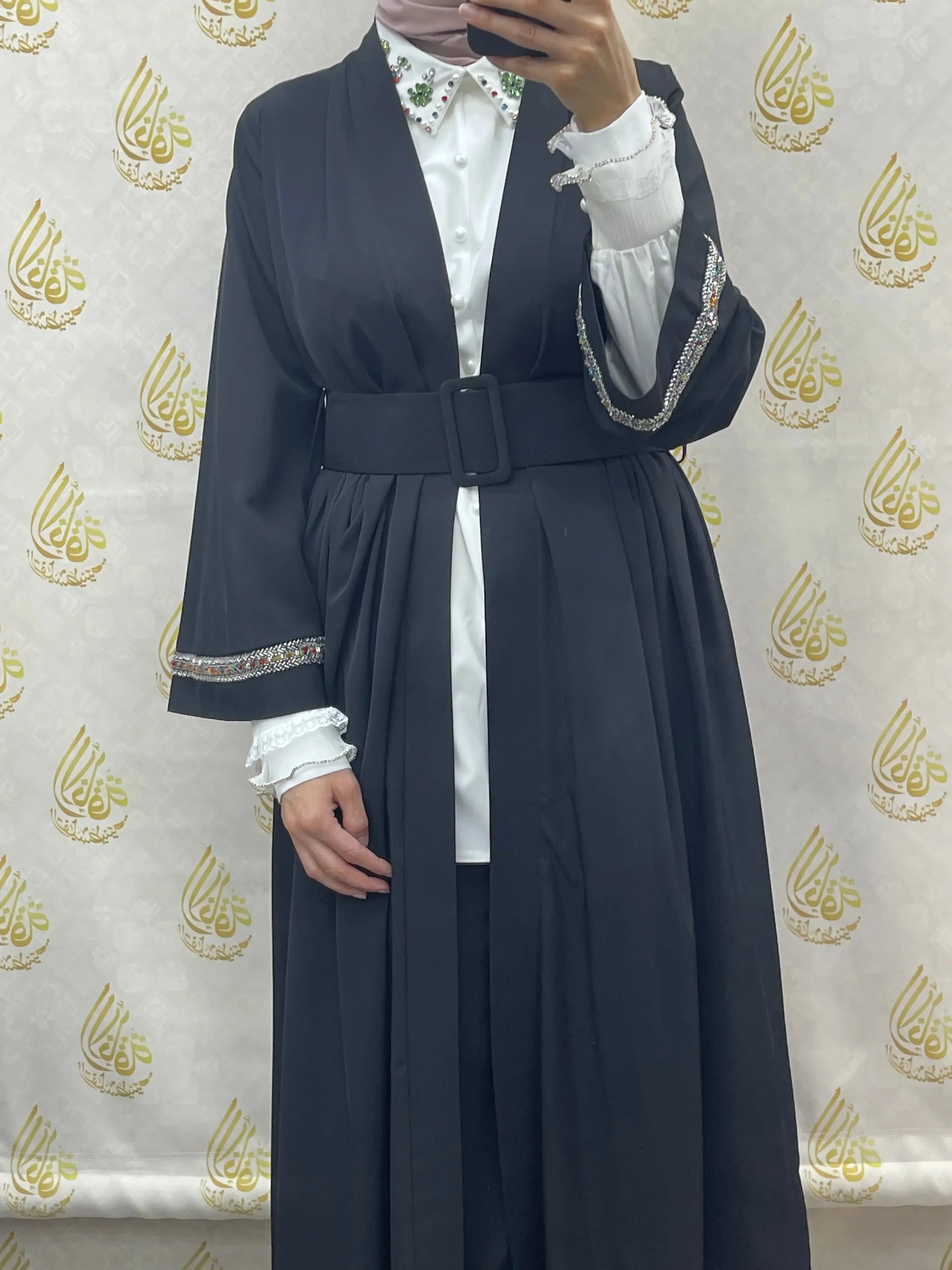 Palestinian Elegance modesty long set featuring black belted outerwear with embellished sleeves over white shirt