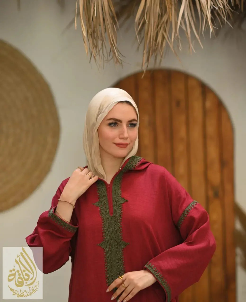 Palestinian Elegance Moroccan embroidered kaftan dress in red with green detailing worn with a beige jilbab