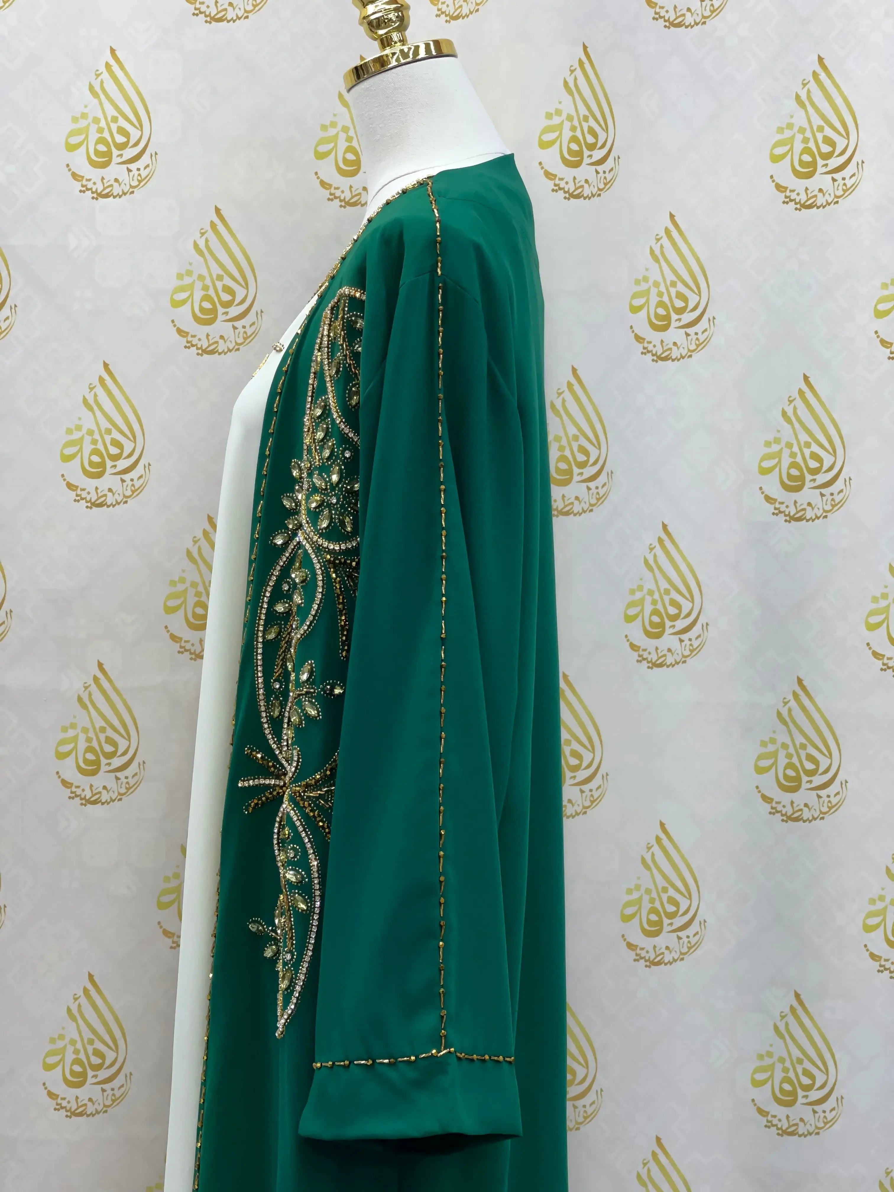 Green open abaya set with gold embroidery displayed on a mannequin by Palestinian Elegance