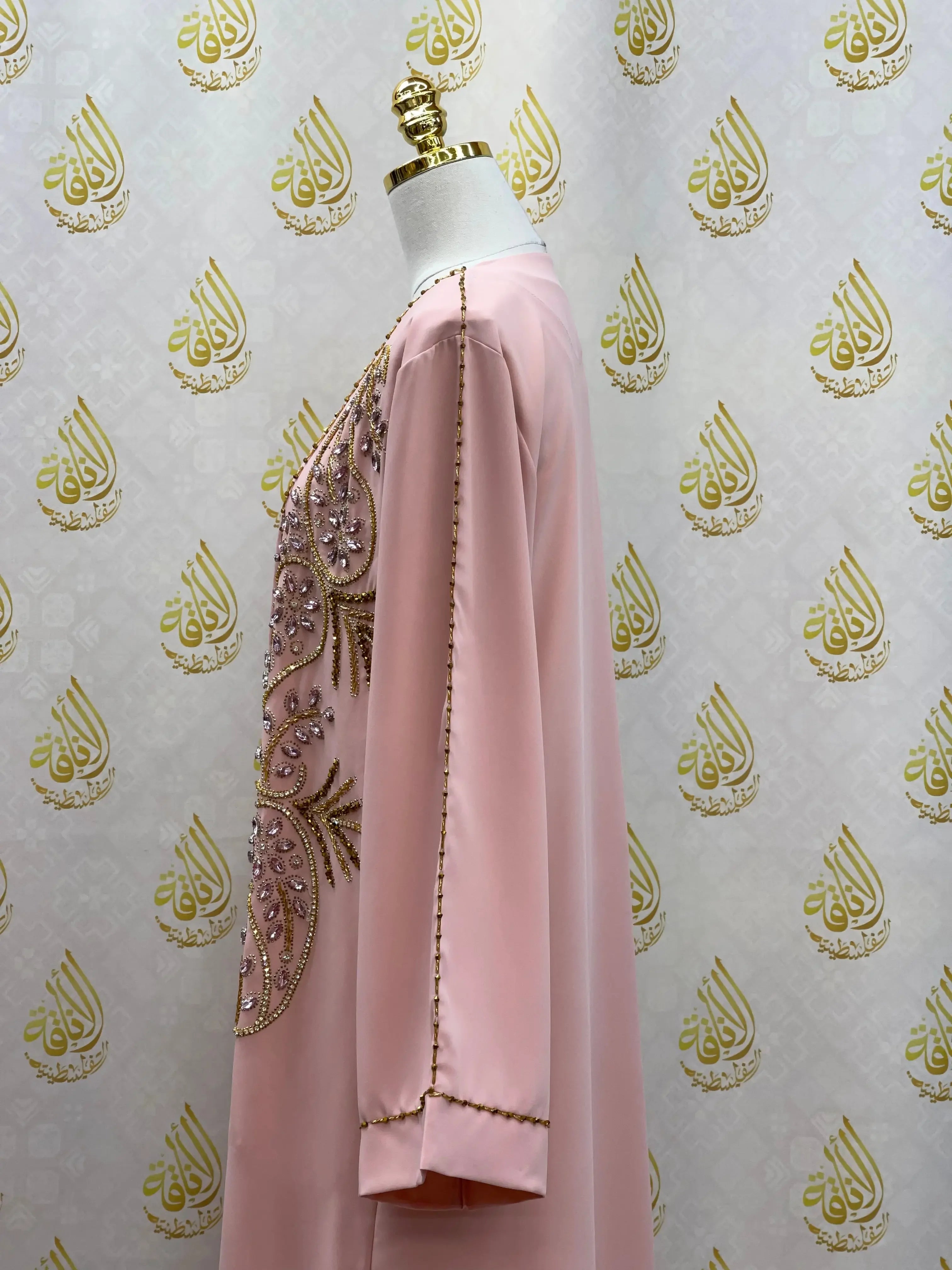 Pink open abaya set with intricate beadwork and embroidery displayed on a mannequin by Palestinian Elegance