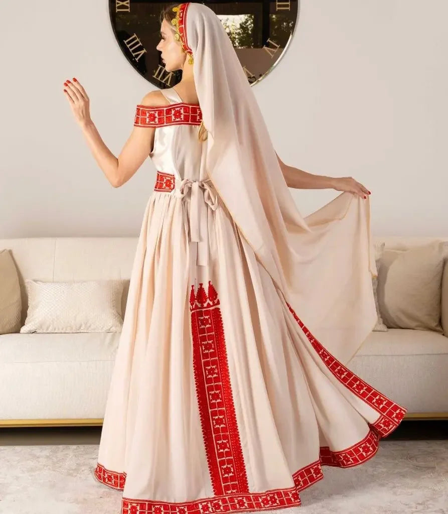 Palestinian bridal thobe with traditional red embroidery and flowing cream fabric from Palestinian Elegance
