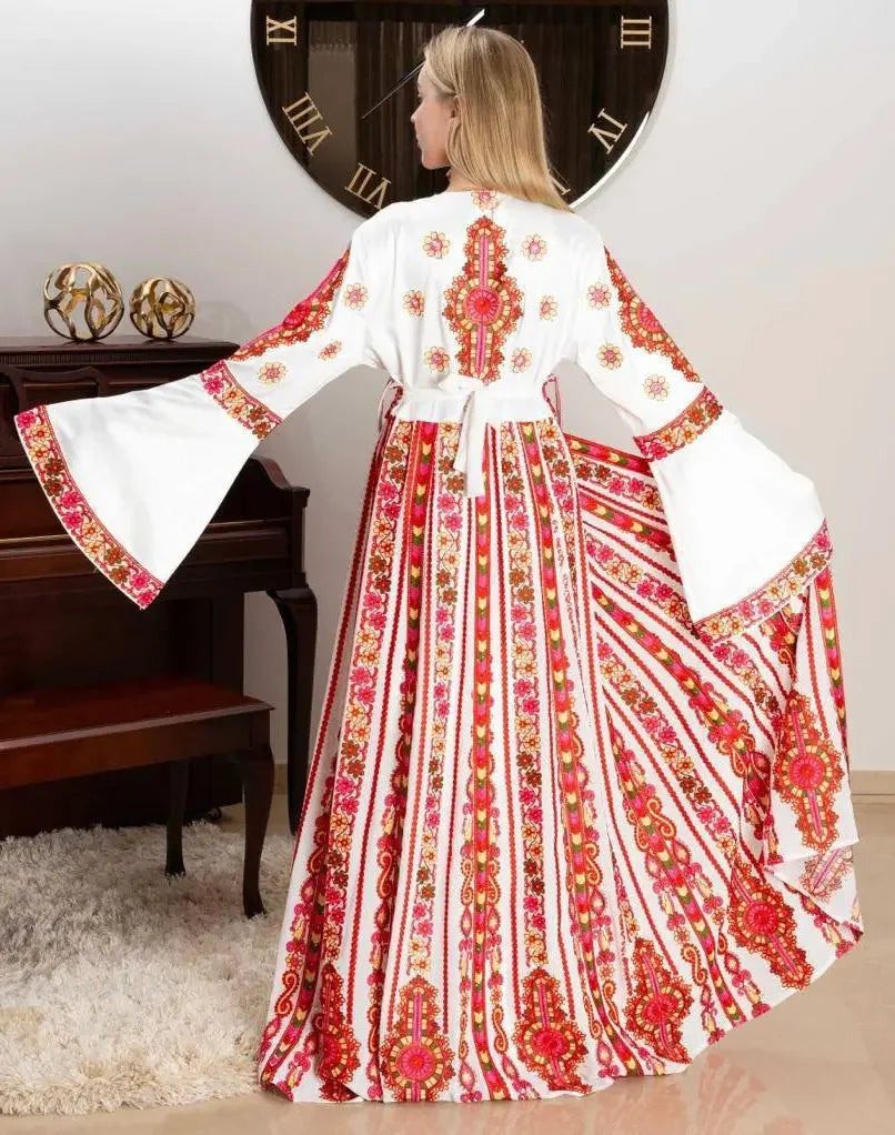 Woman wearing a white and red Palestinian bridal thoub dress with intricate floral embroidery and wide bell sleeves