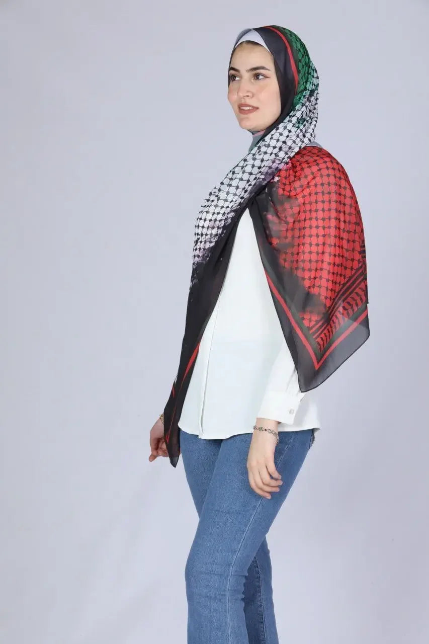 Palestinian chiffon hijab with traditional black red and white patterns worn by woman with white blouse and blue jeans