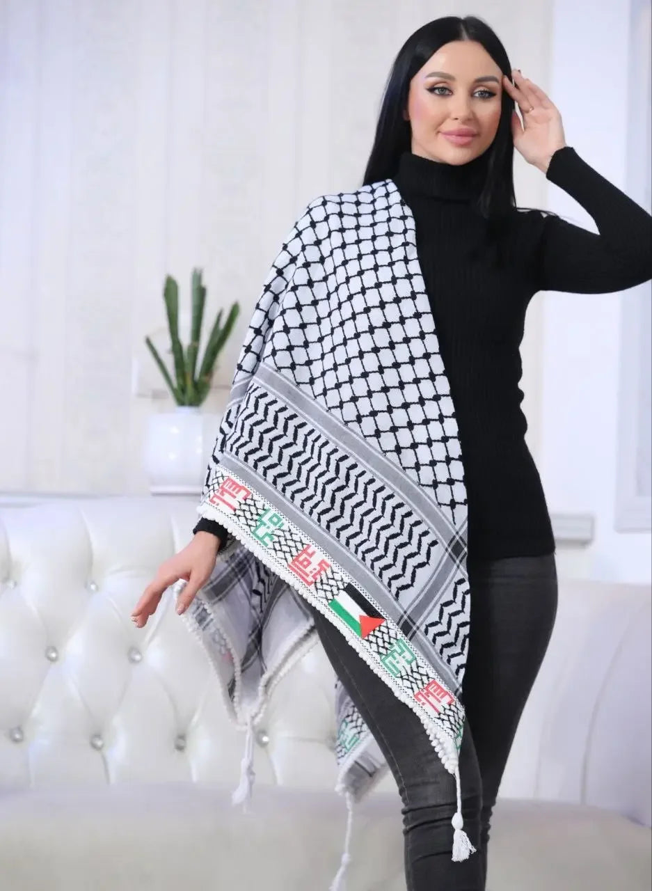 Woman wearing Palestinian embroidered kuffiyeh in black and white with traditional patterns and tassels