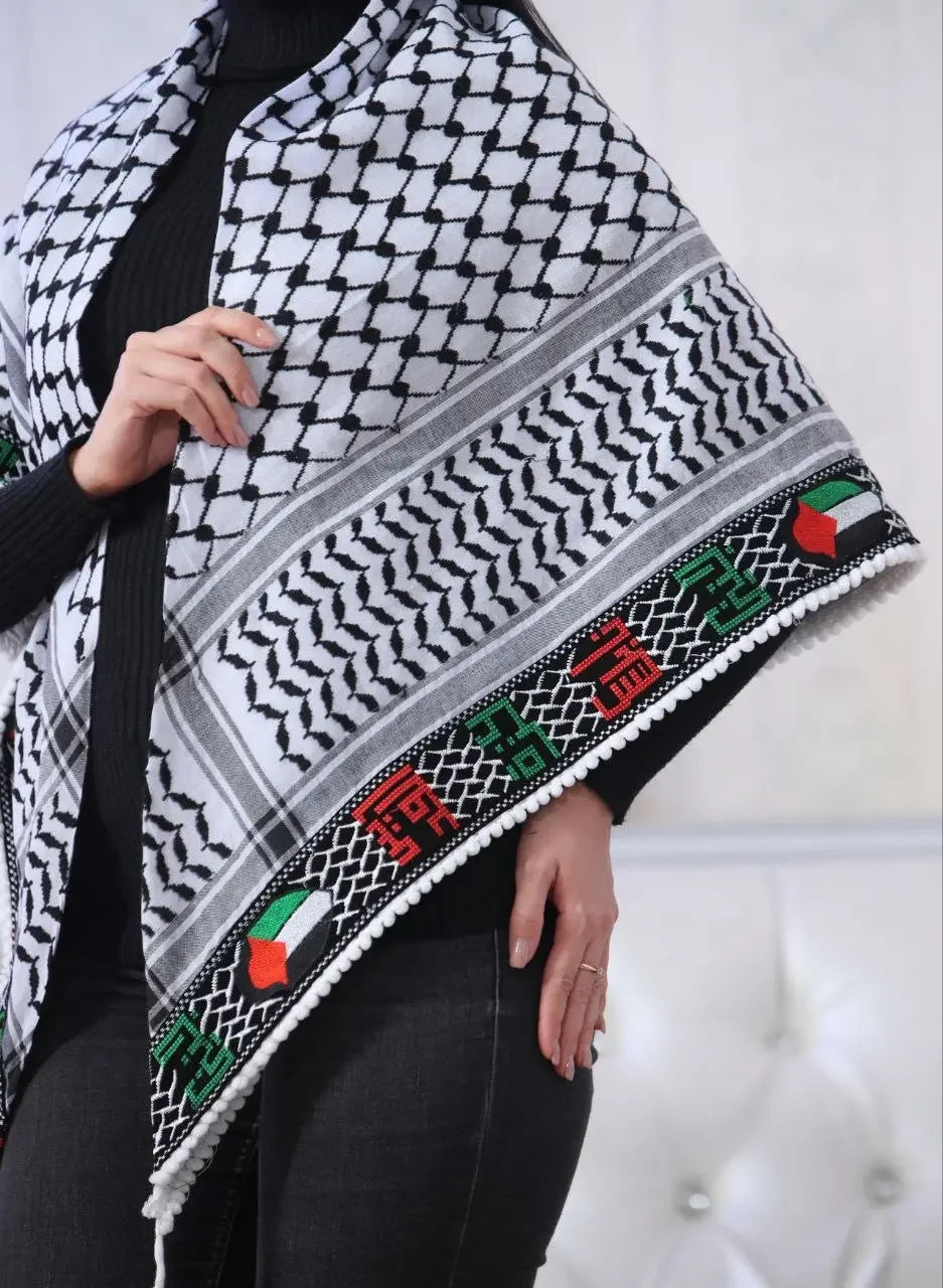 Embroidered Palestinian kuffiyeh with traditional black and white pattern and colorful detailed border worn over black outfit